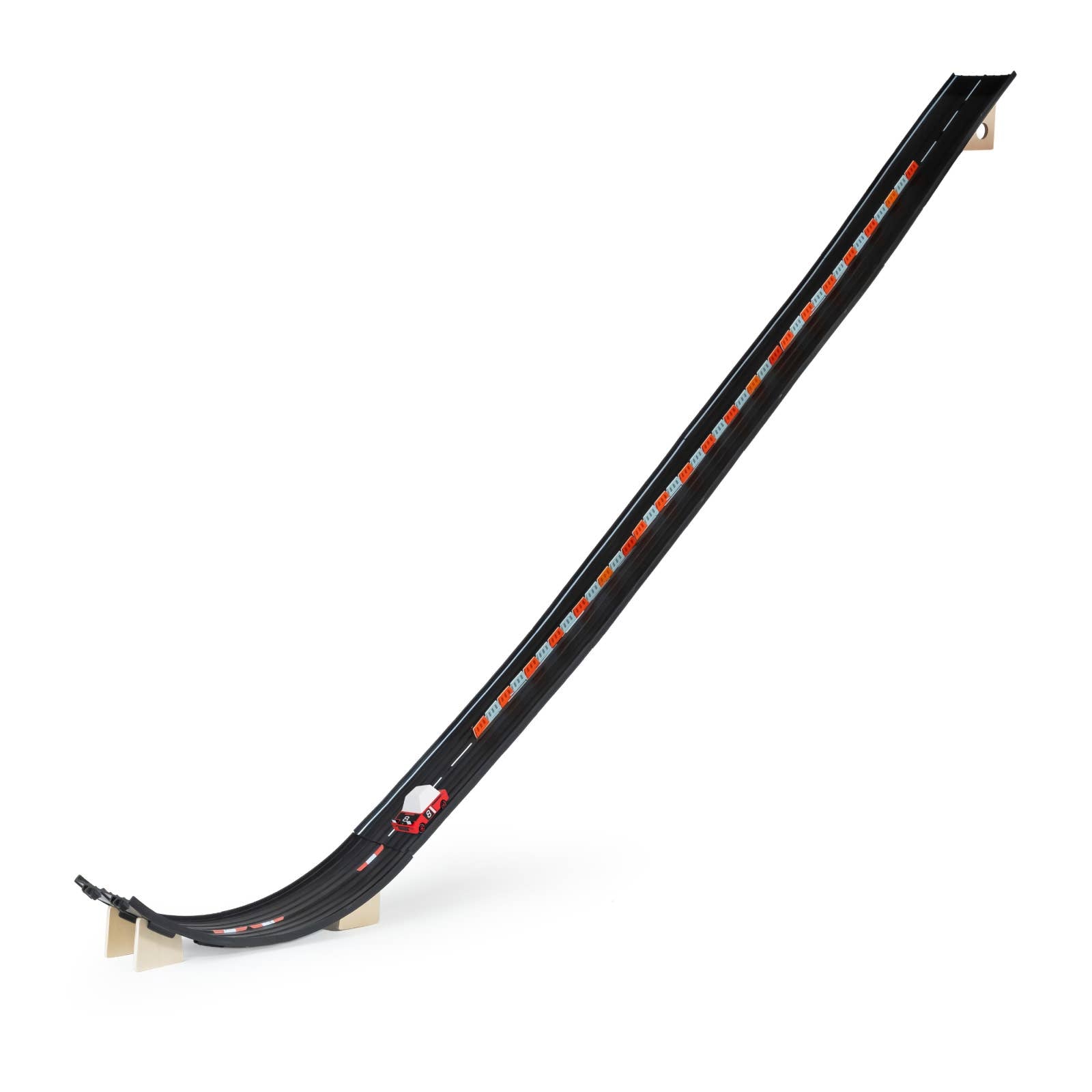 Black toy race track with a small car on a white background