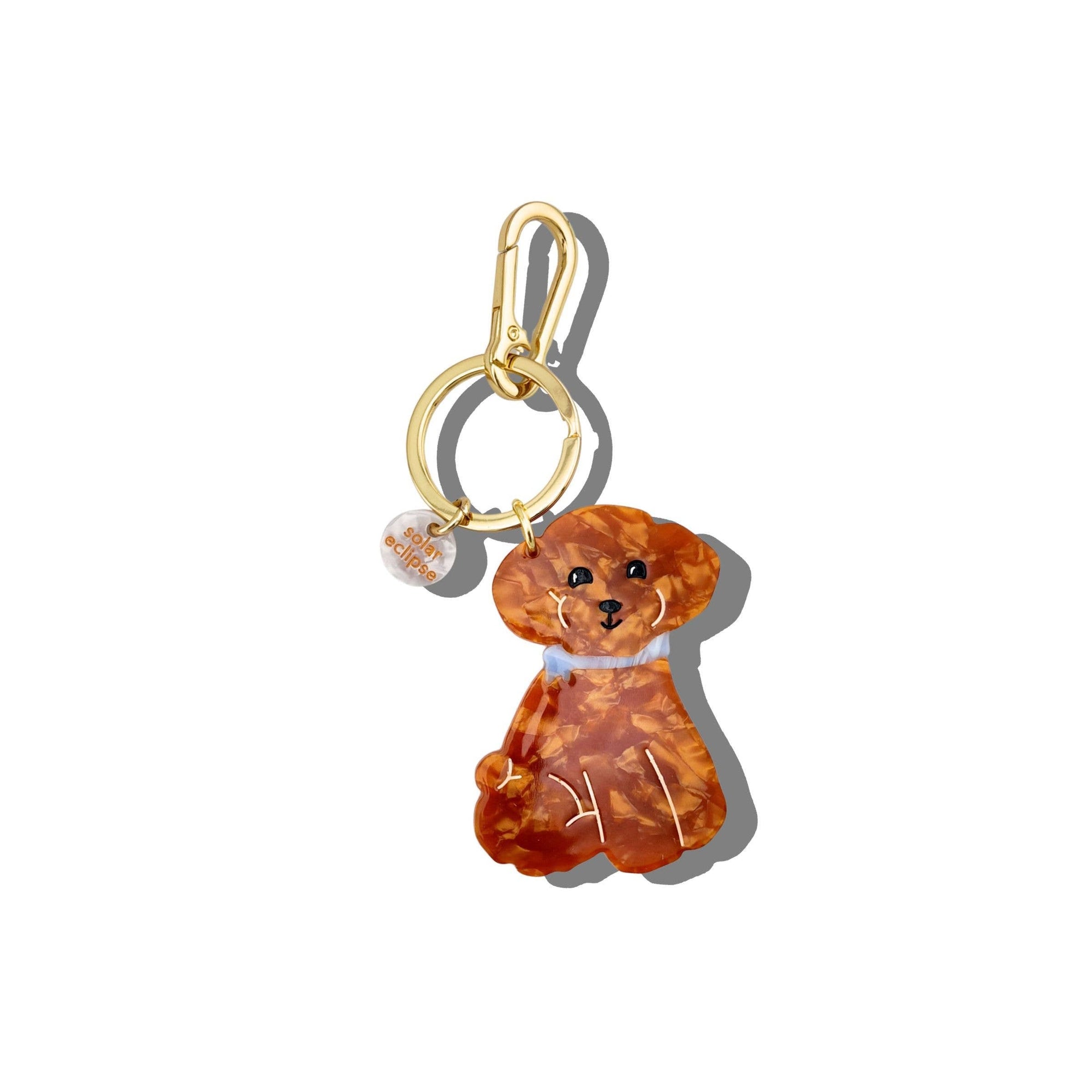 Dog-shaped keychain with gold ring on a white background
