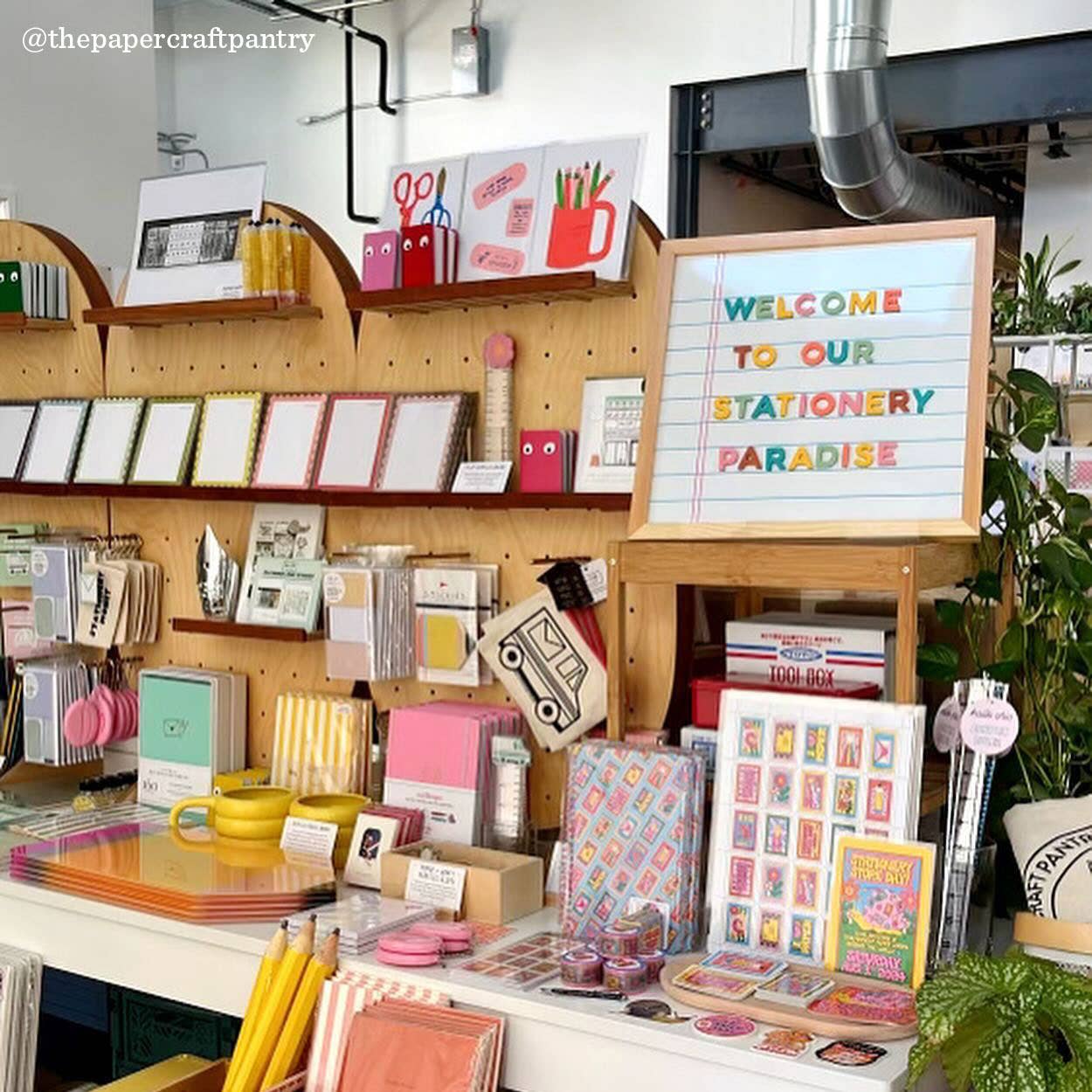 Stationery store with shelves displaying various stationery items and a sign welcoming customers.