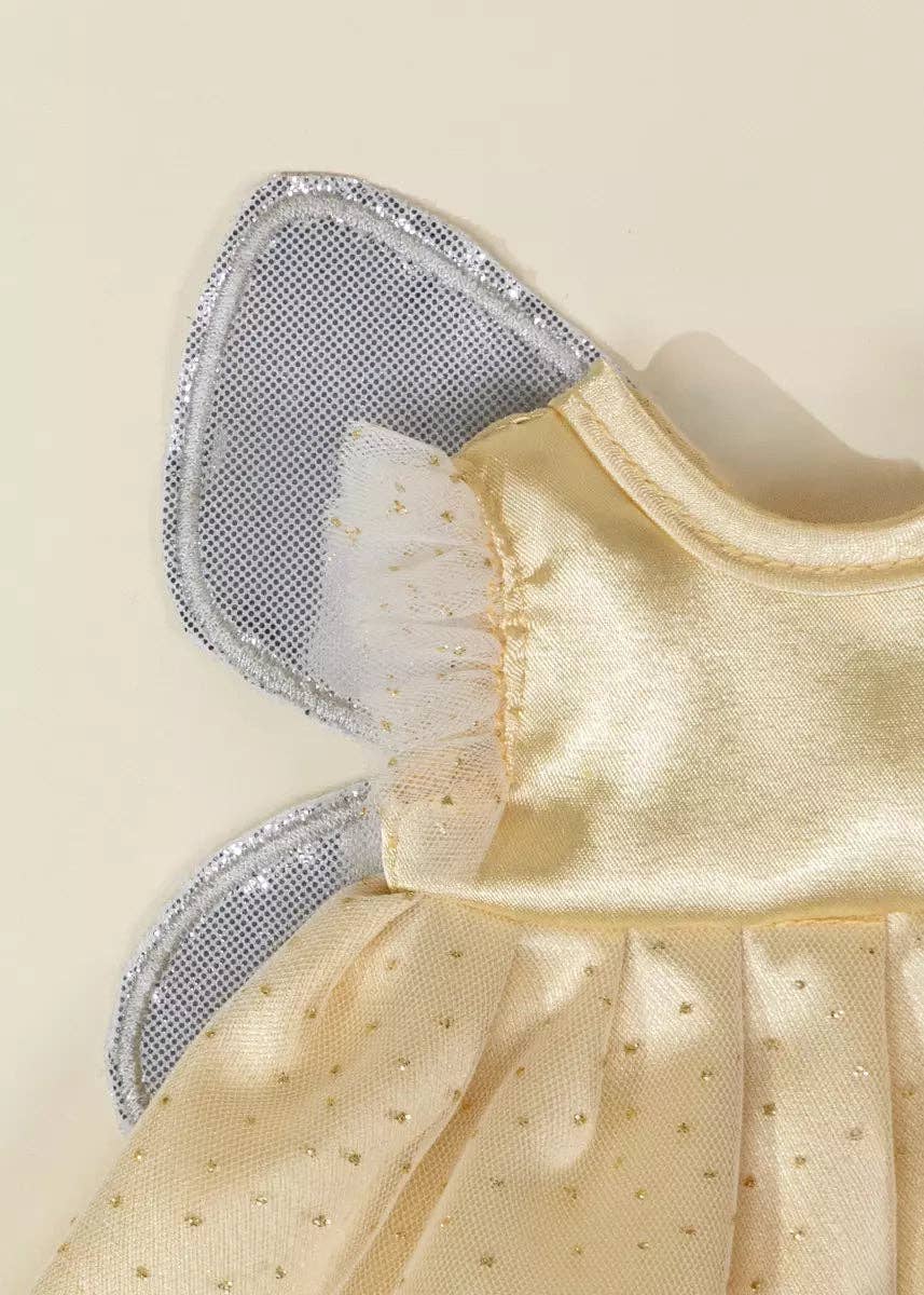 Close-up of a pale yellow angel costume dress with silver glitter-trimmed wings and a ruffled tulle collar, shown on a plain light beige background.