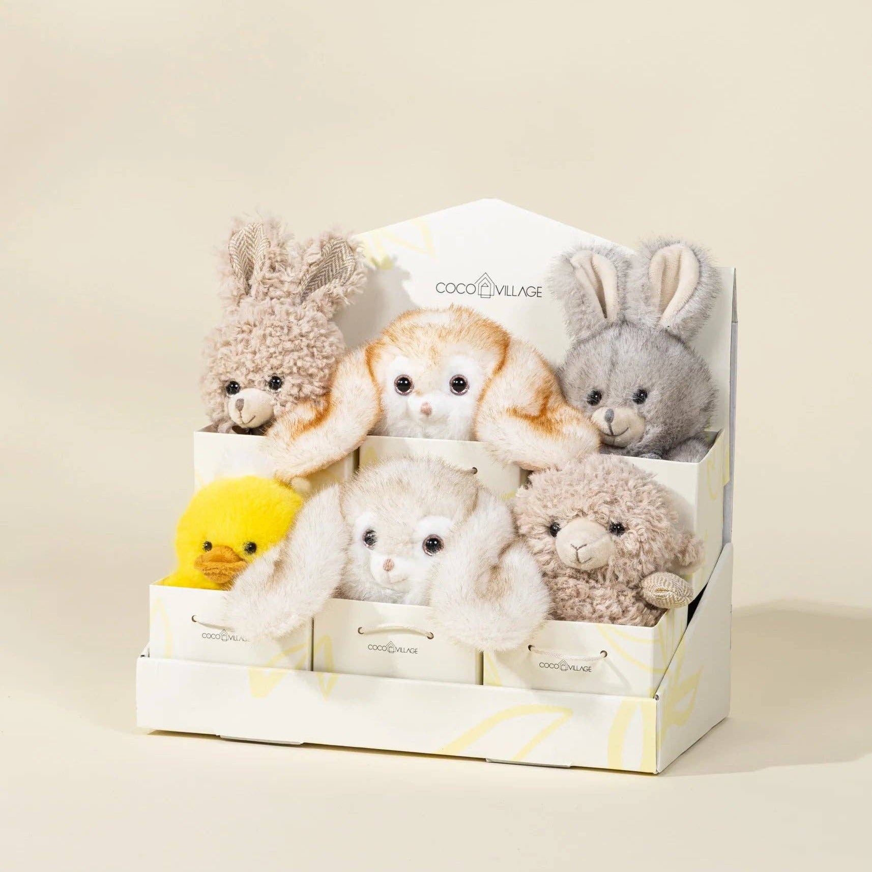 Set of small plush toys in a box on a beige background