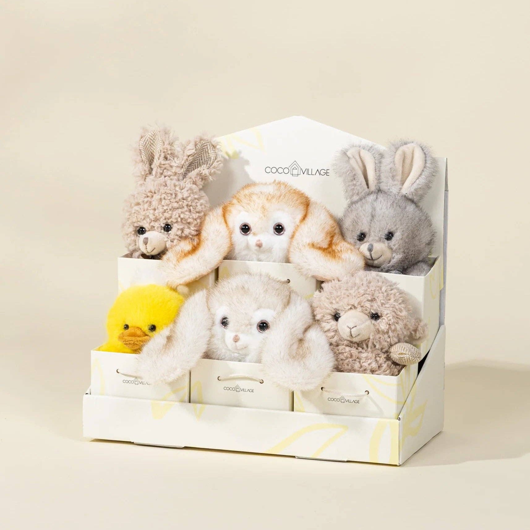 Set of small plush toys in a box on a beige background