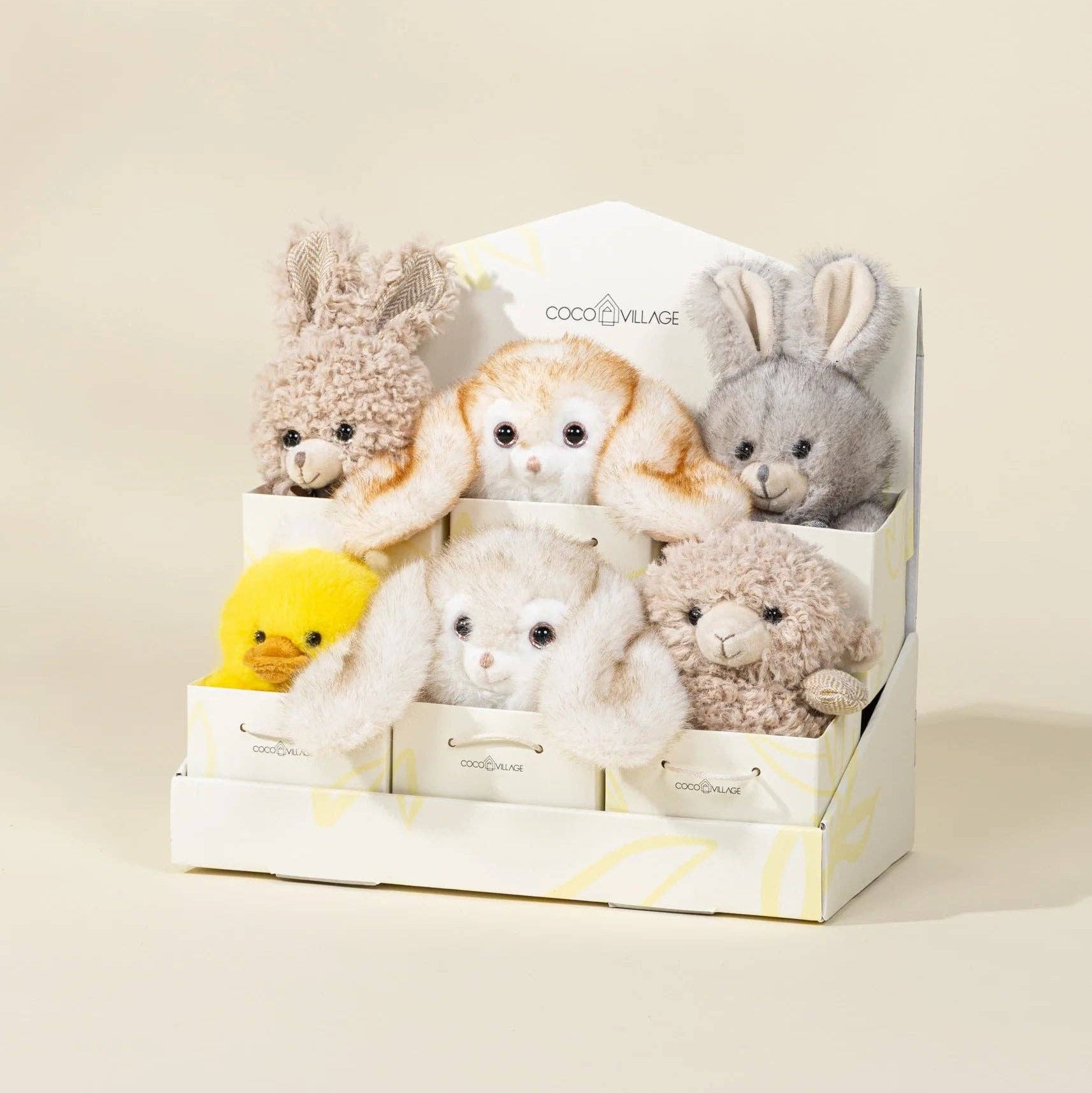 Set of small plush toys in a box on a beige background