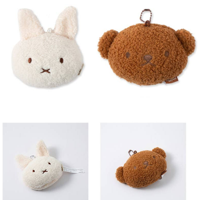 Two plush keychains, one white with rabbit ears and another brown with bear ears, on a white background.