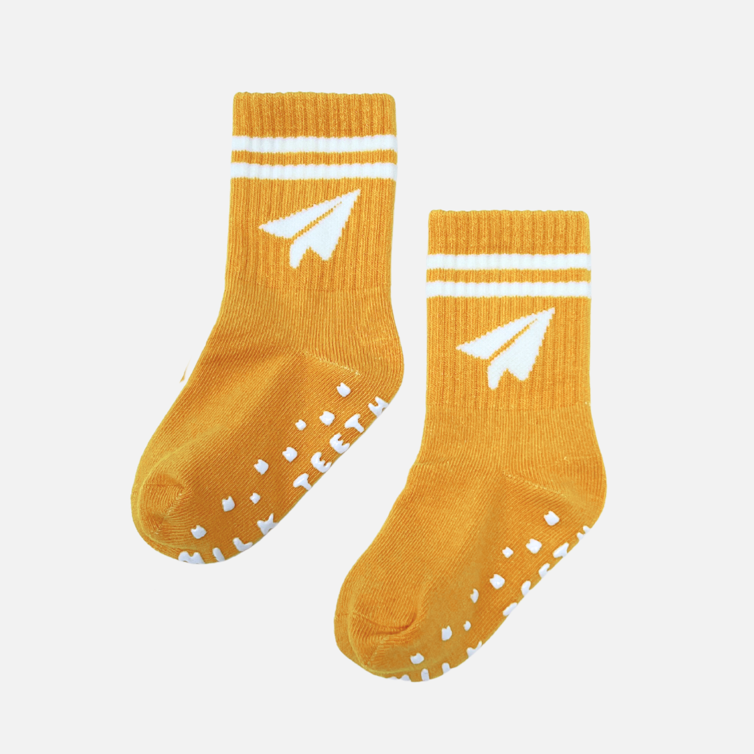 Pair of mustard yellow socks with white stripes and a logo on a light gray background