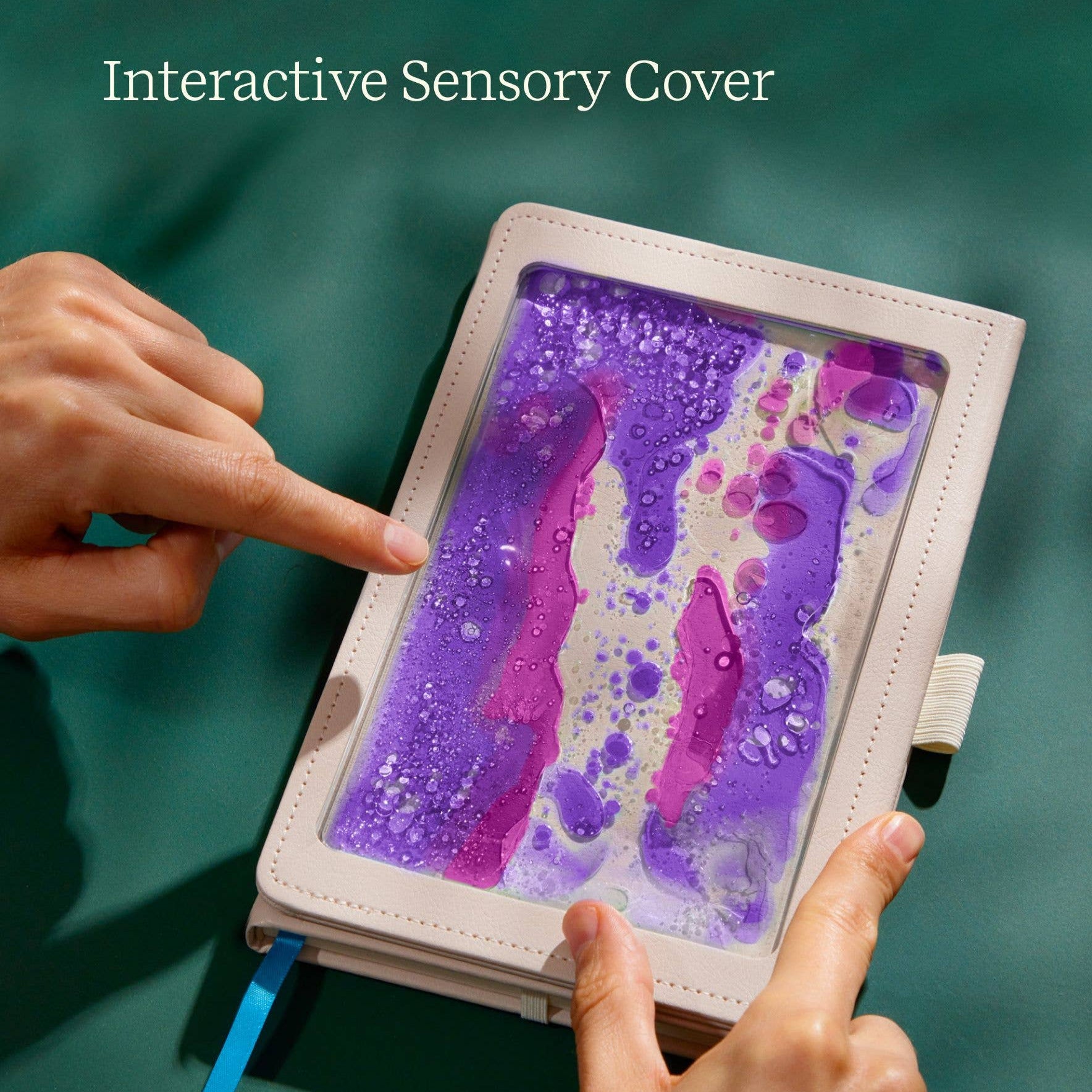 Interactive Sensory Cover with colorful design and hands interacting with it on a teal background