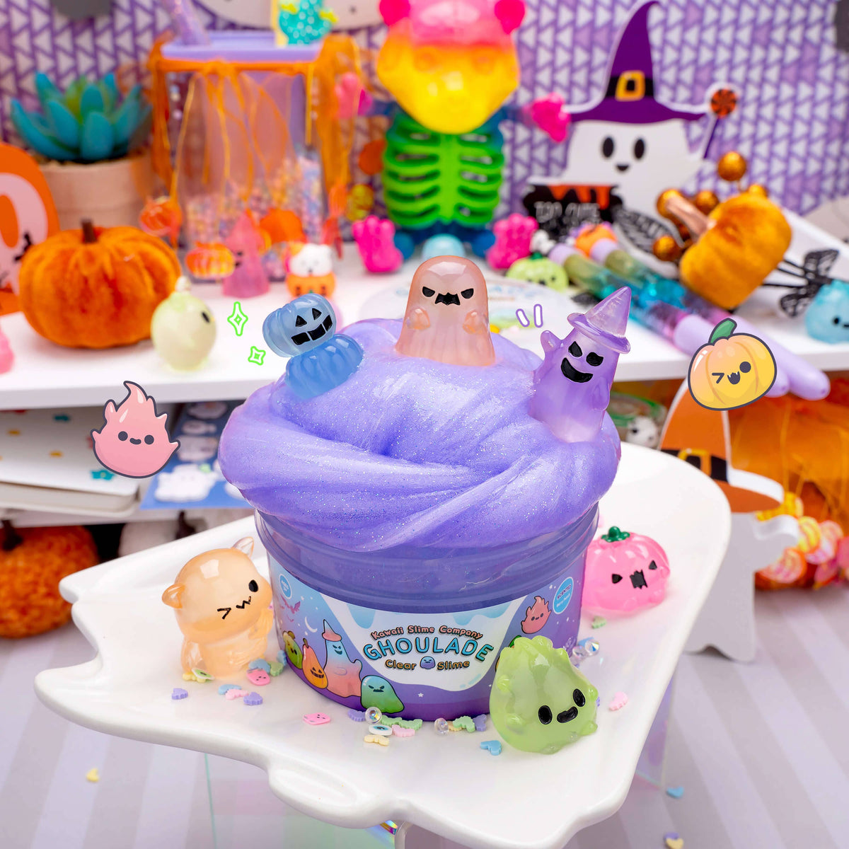 Purple slime toy with ghost characters on a white stand, surrounded by Halloween-themed decorations.