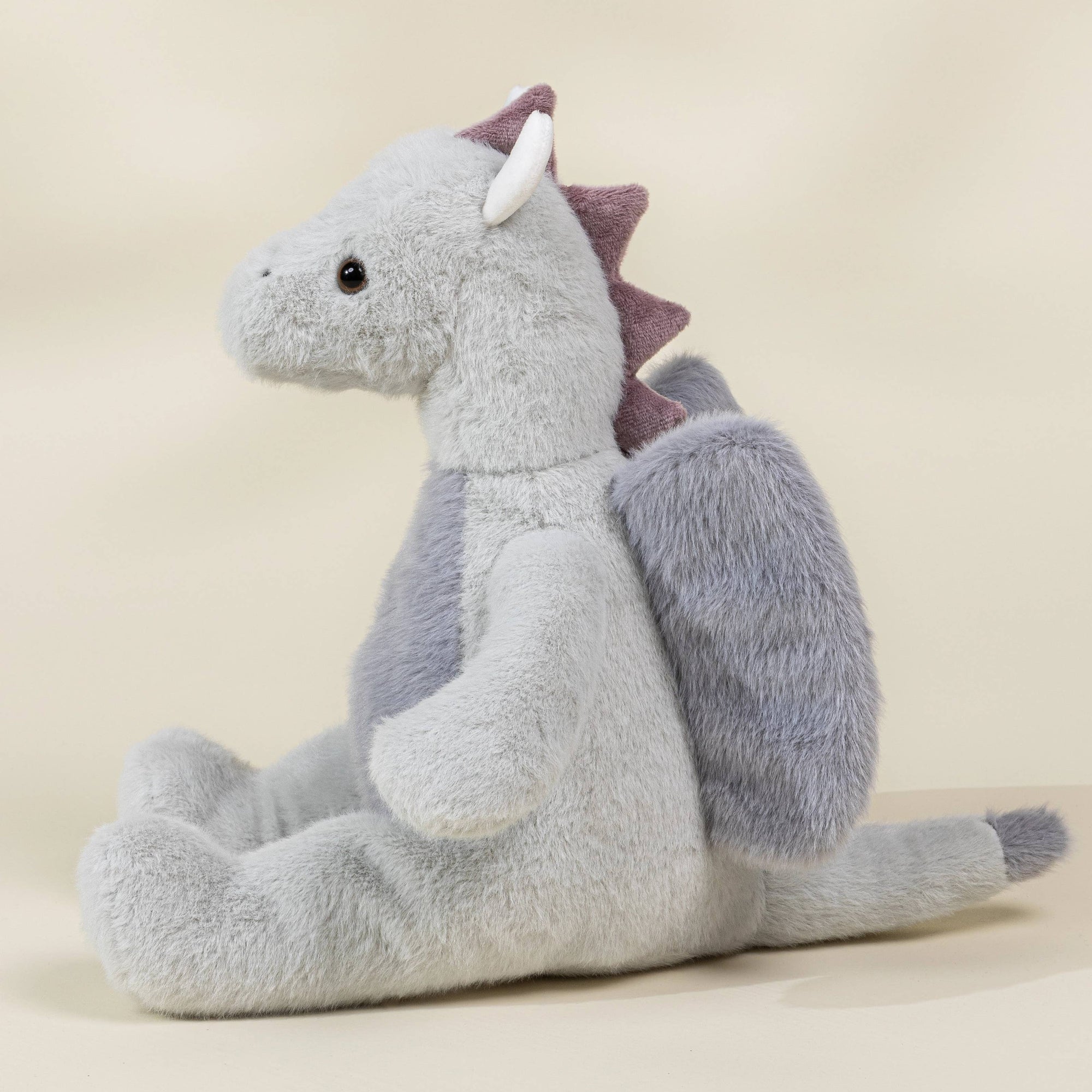 Plush dragon toy on a beige background