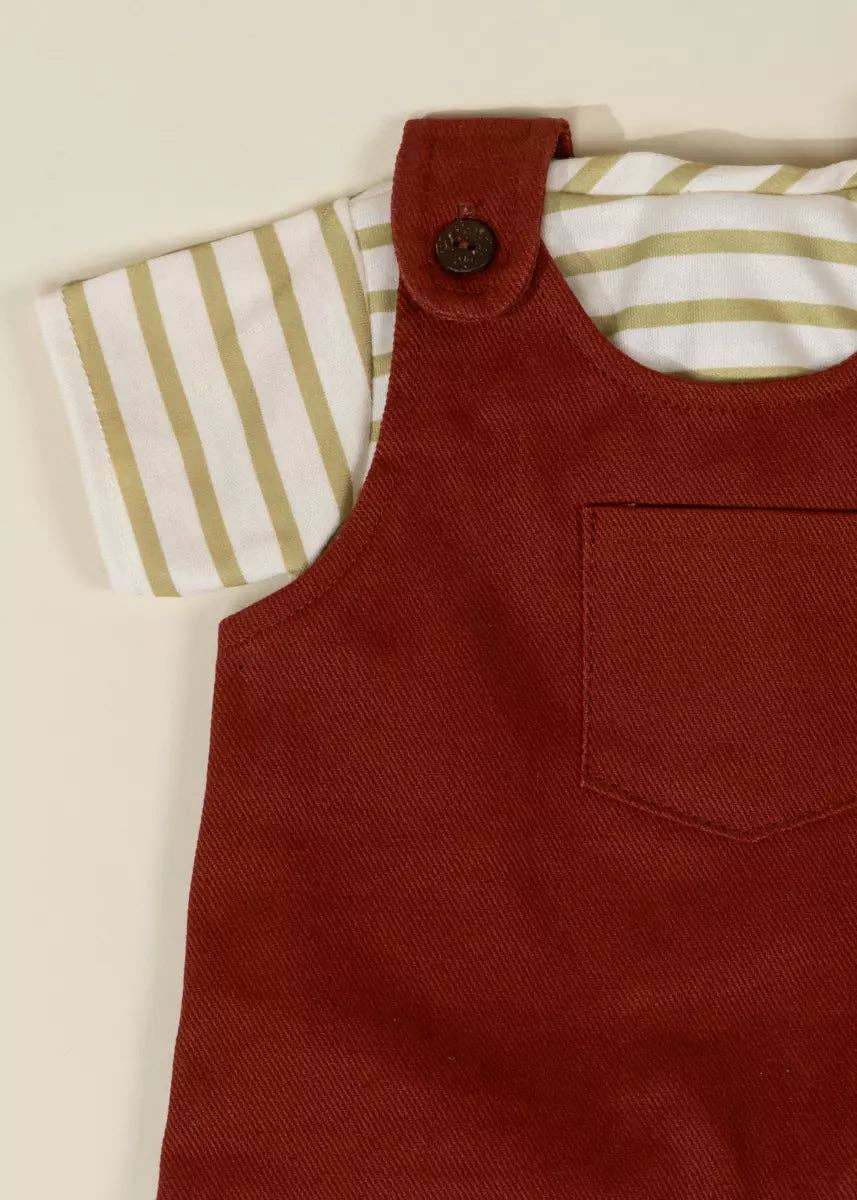Red denim dress with a striped shirt underneath on a beige background