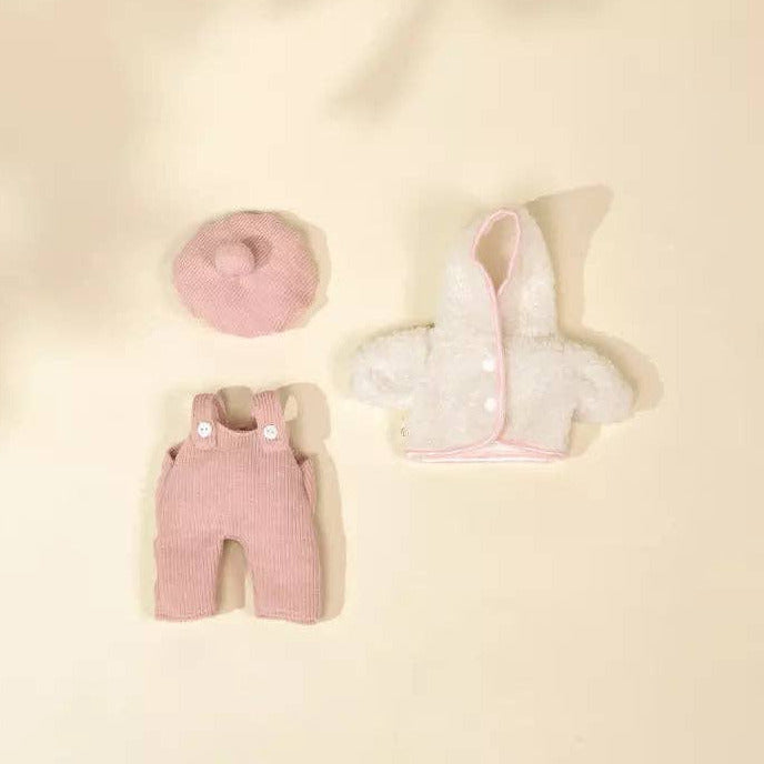 Baby pink romper and white bib on a beige background