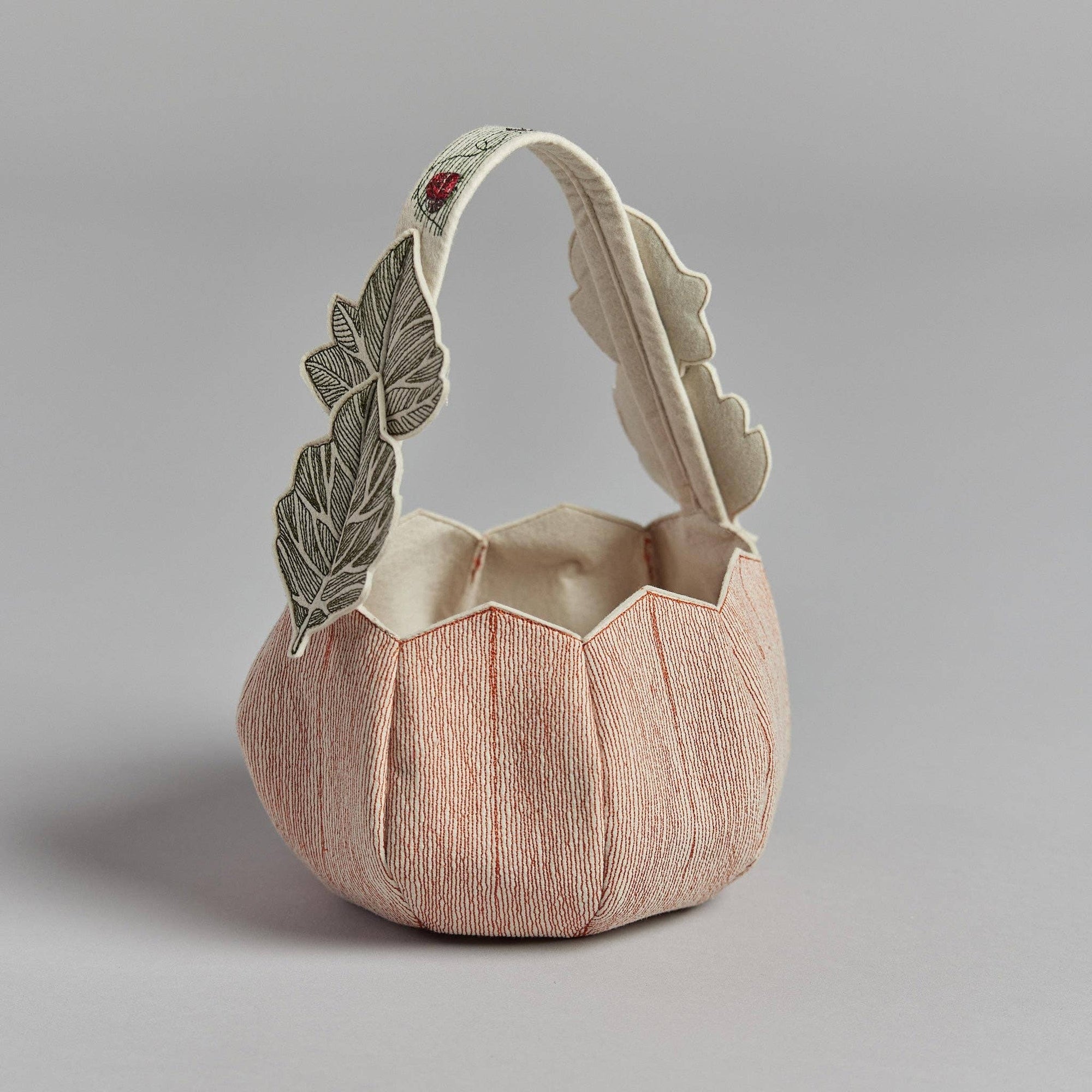 Decorative ceramic basket with feather design on a gray background