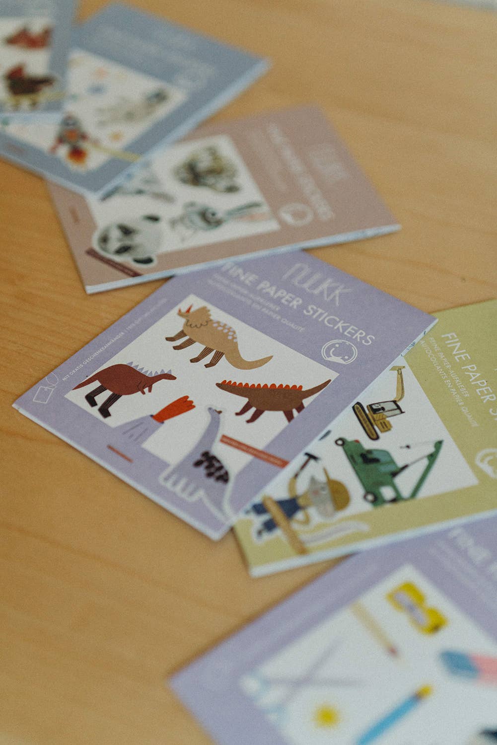 Sticker books with illustrations on a wooden surface