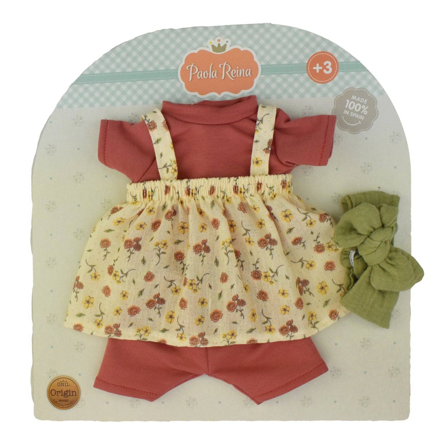 A 3-piece baby clothing set by Paola Renna, including a coral pink short-sleeve top and shorts, a cream floral romper, and an olive green bow headband, all displayed on a branded cardboard backing.