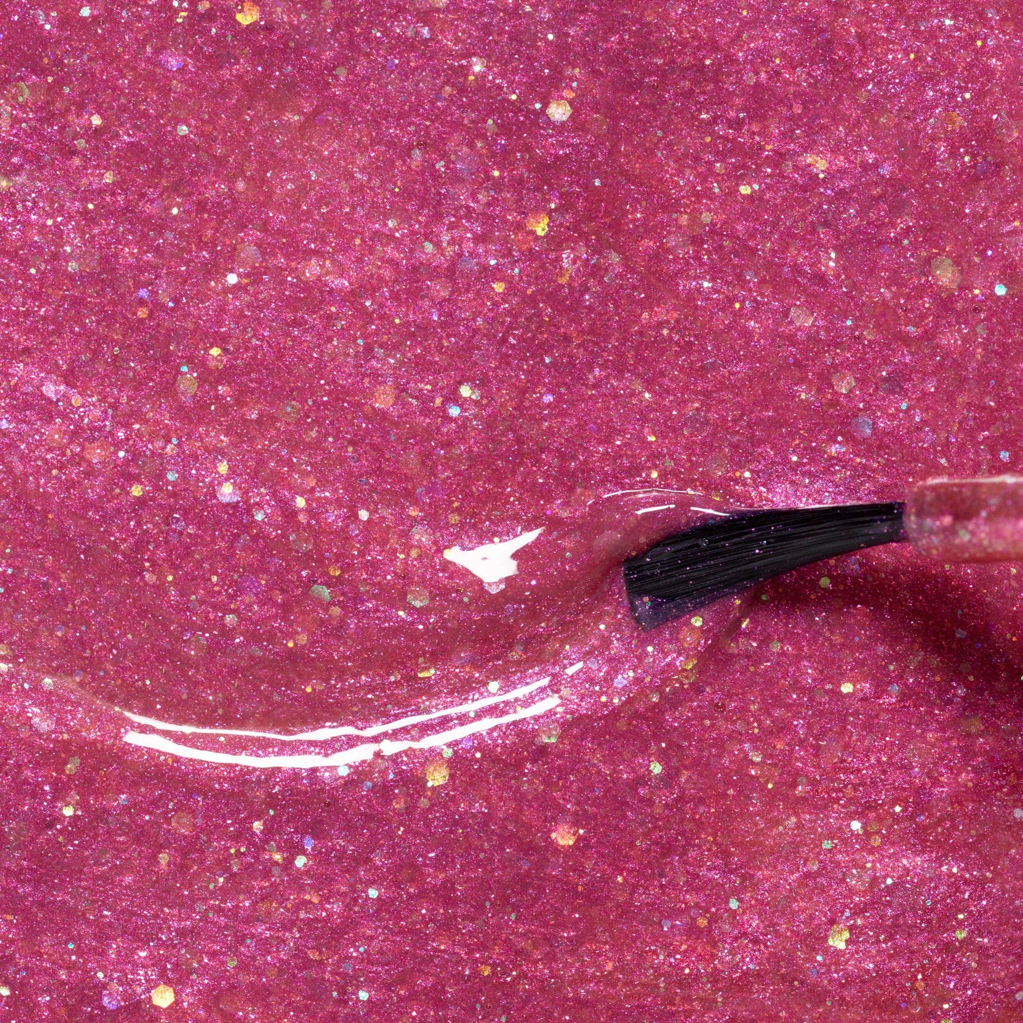 Close-up of pink glittery substance with a black applicator