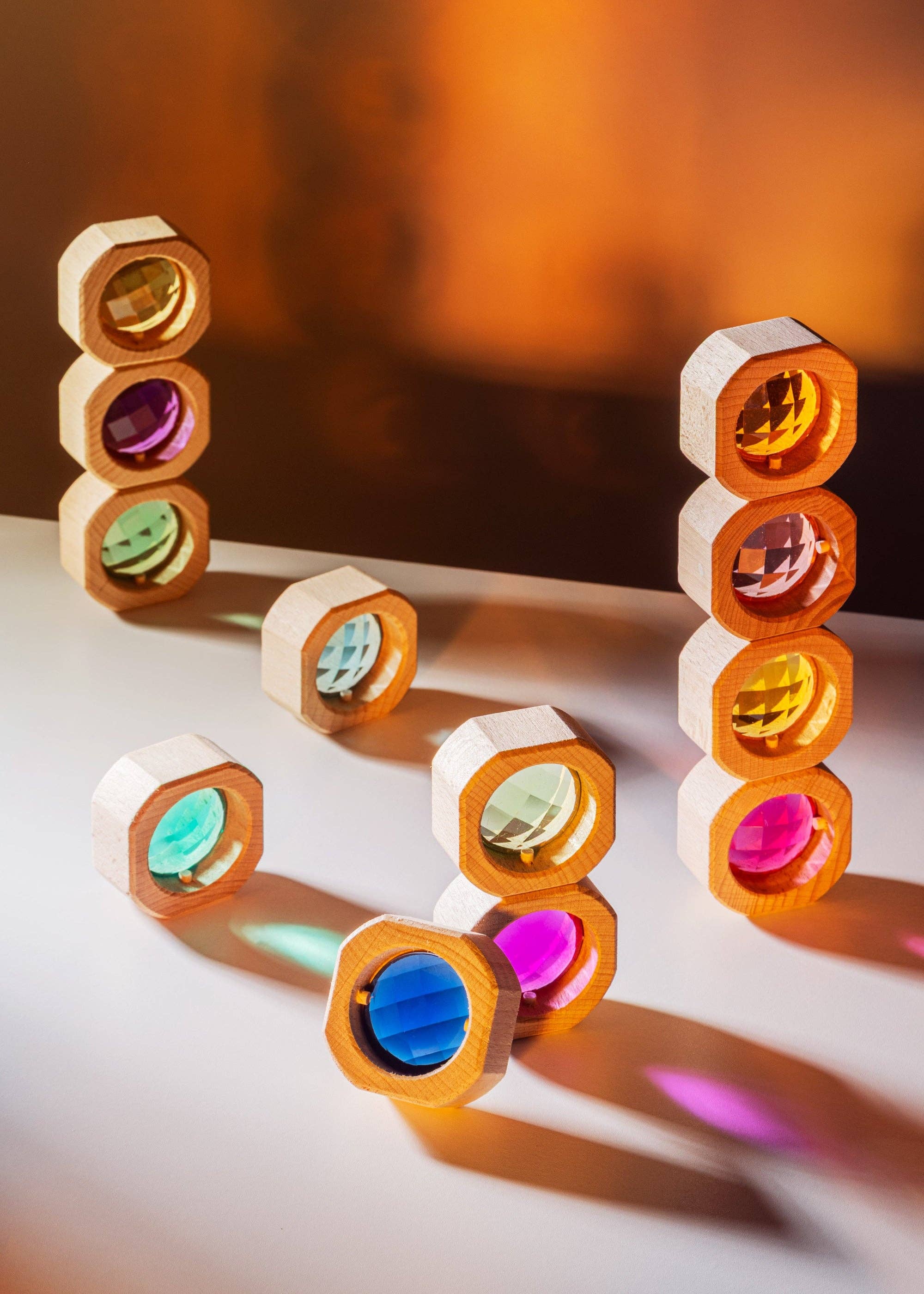 Colorful geometric shapes on a white surface with a blurred orange background