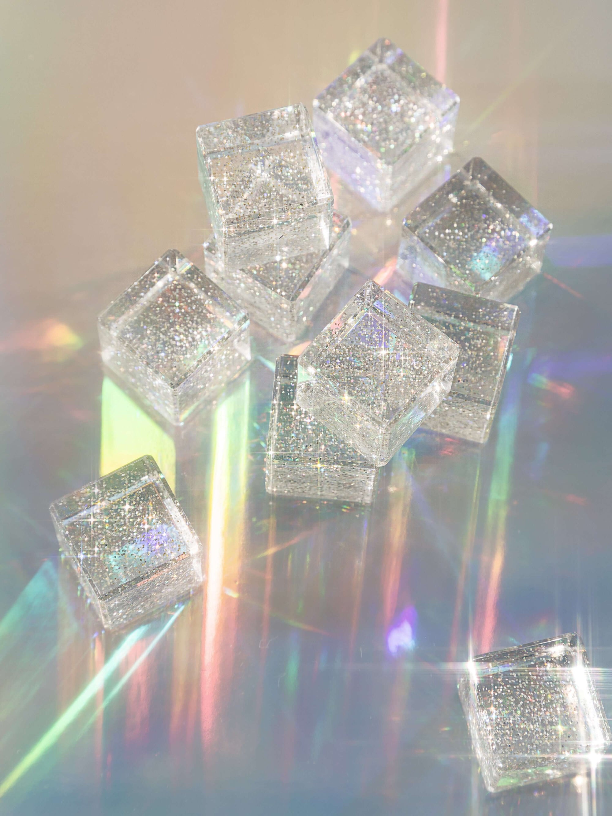 Decorative silver cubes with sparkling gemstones on a reflective surface
