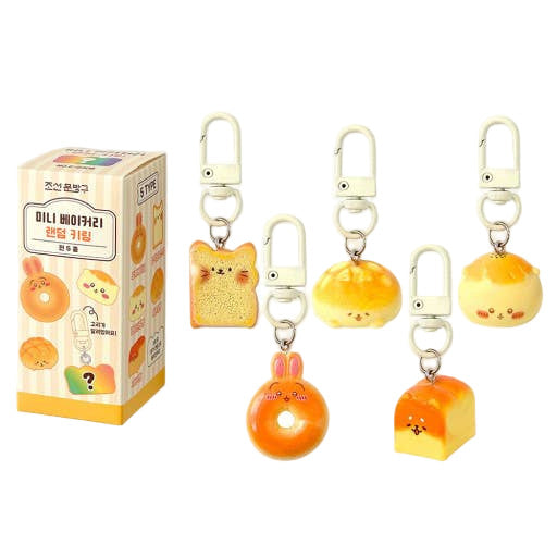Set of cute keychains shaped like bread characters with a packaging box on a white background