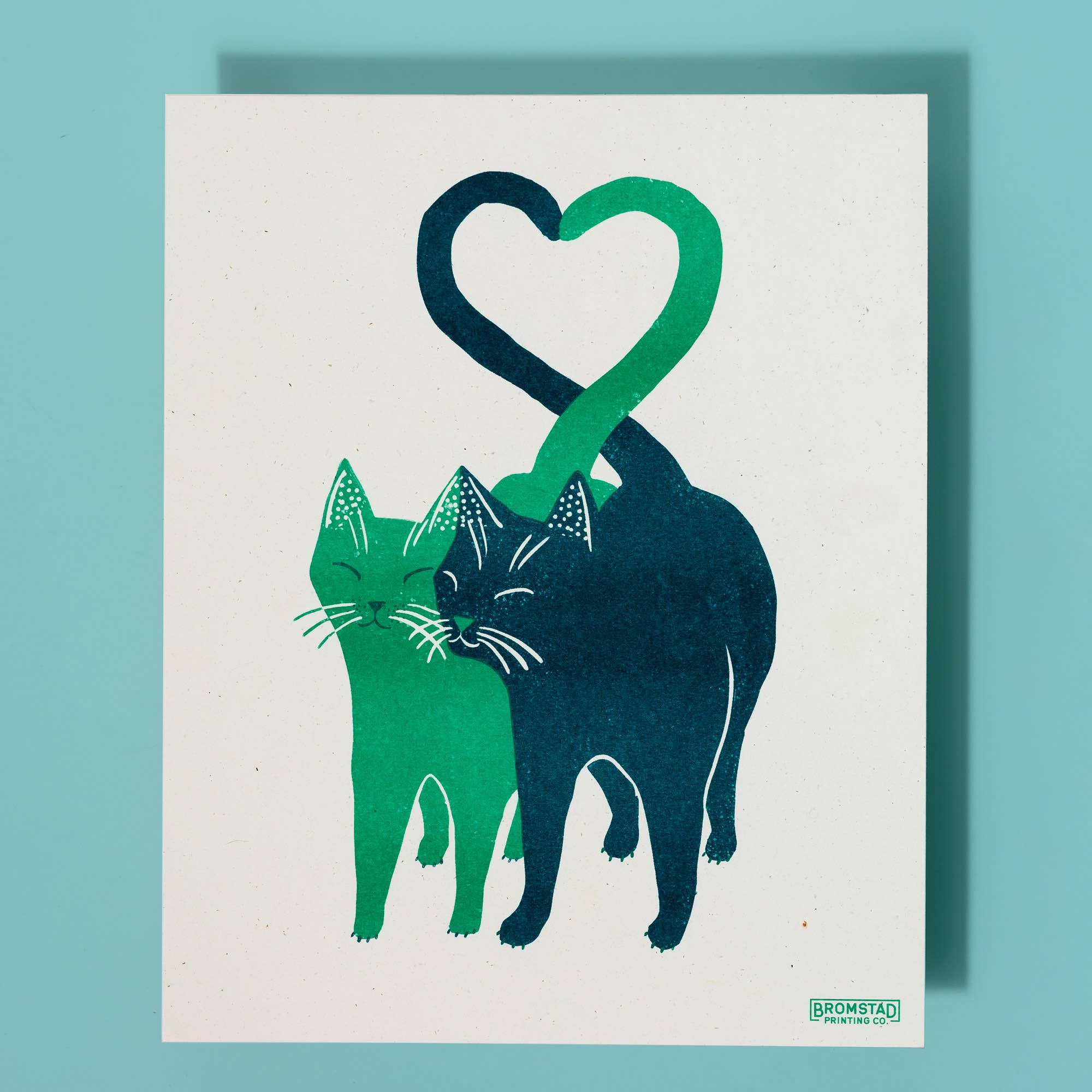Illustration of two cats forming a heart shape on a white background with a blue border.