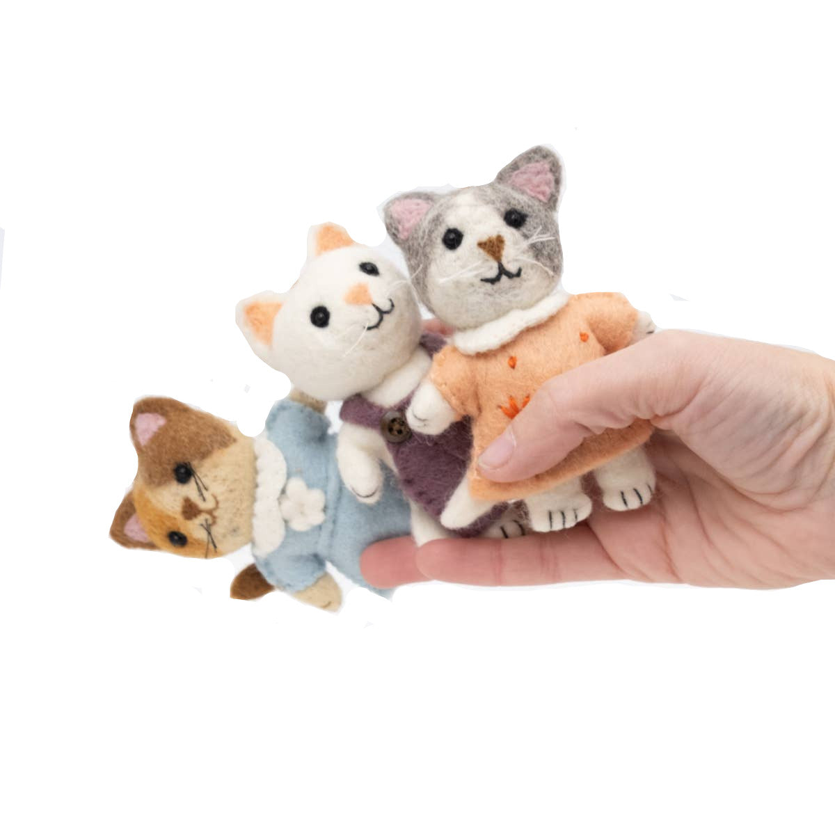 Hand holding four small cat-shaped keychains against a white background