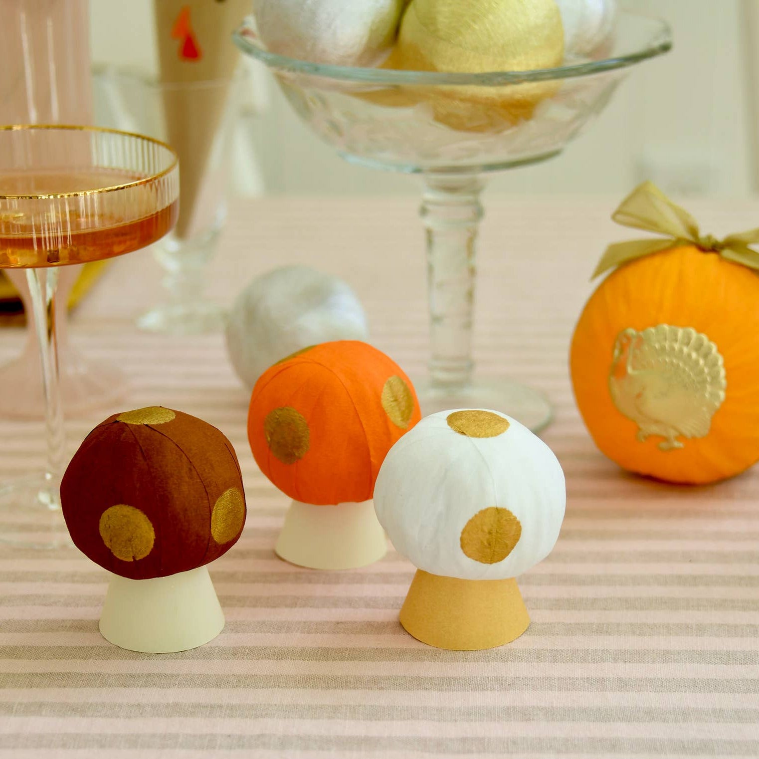 Decorative mushroom surprise balls on a table with cocktail glasses in the background
