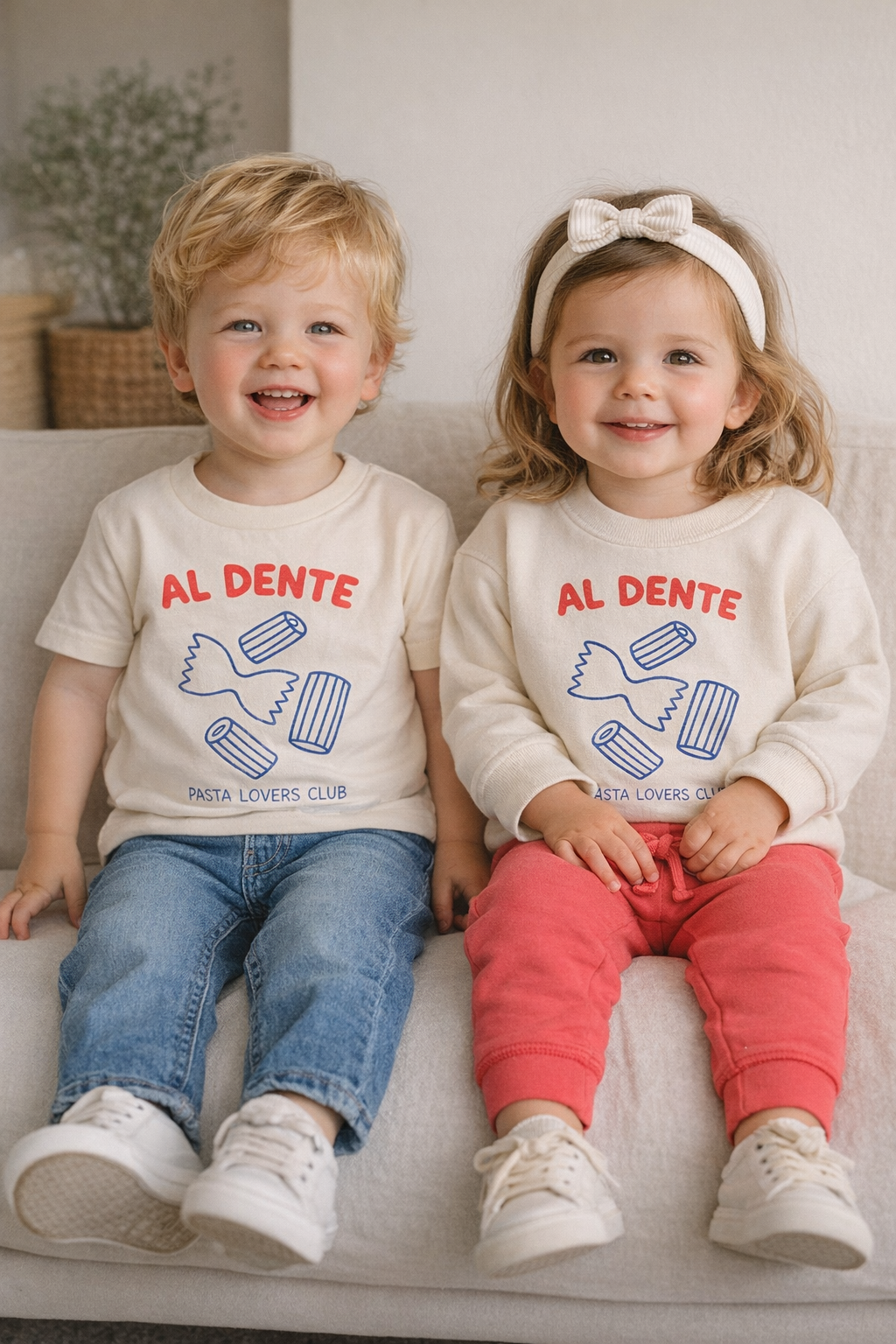 Two children sitting on a couch wearing matching 'Al Dente' shirts.