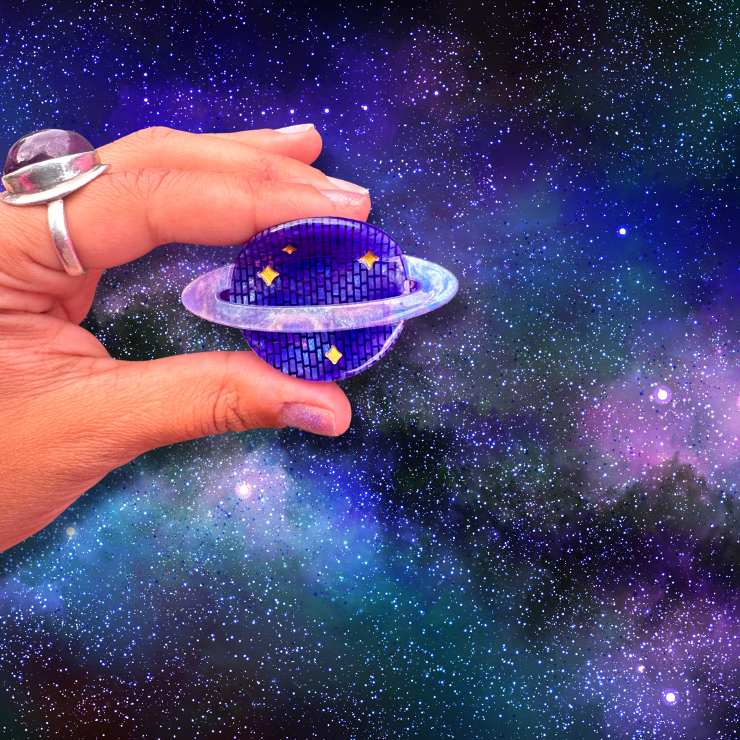 Hand holding a planet-shaped object against a starry space background