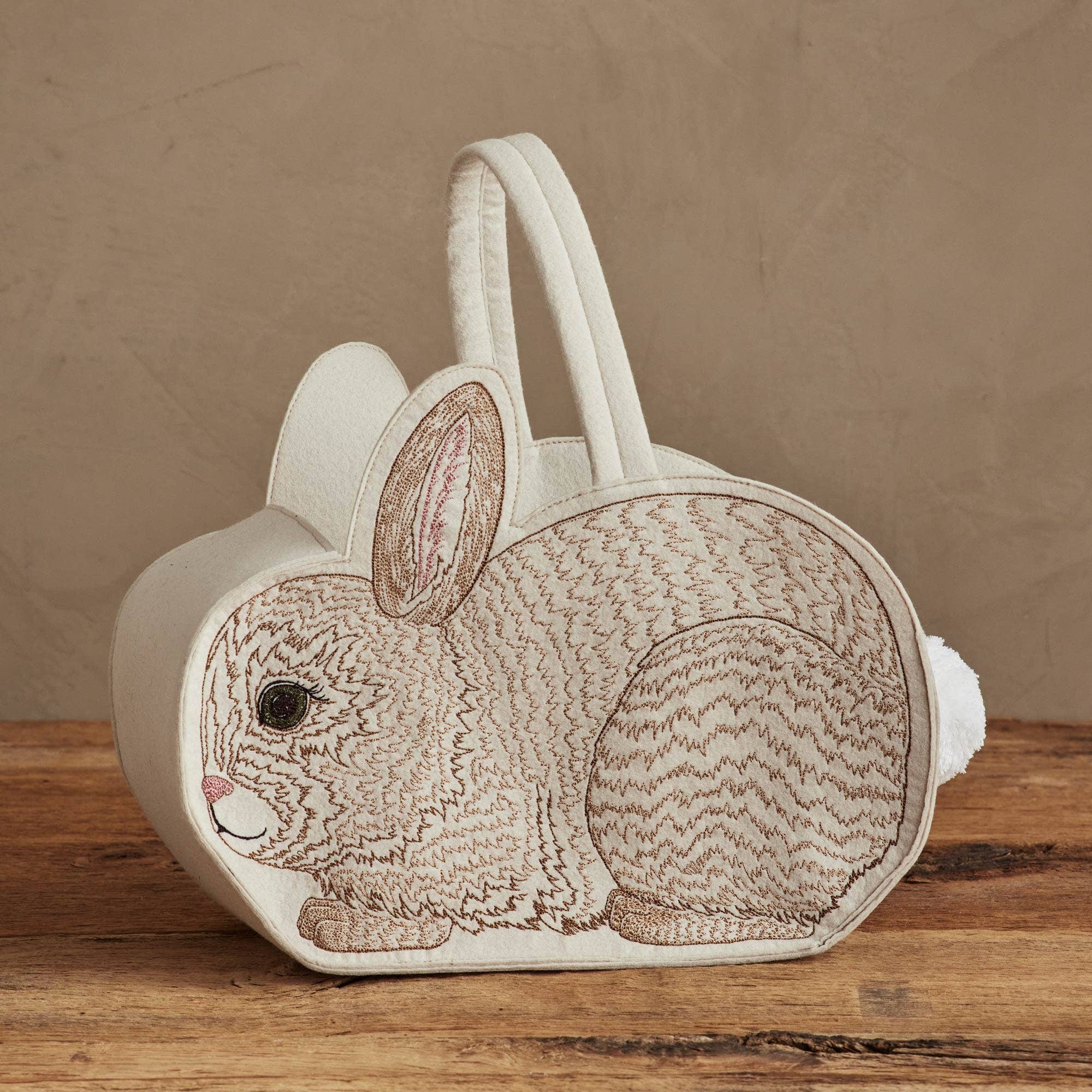 Bunny-shaped bag with a textured pattern on a wooden surface and brown background