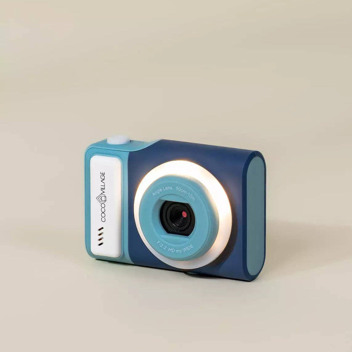 Blue digital camera with a white label on a beige background