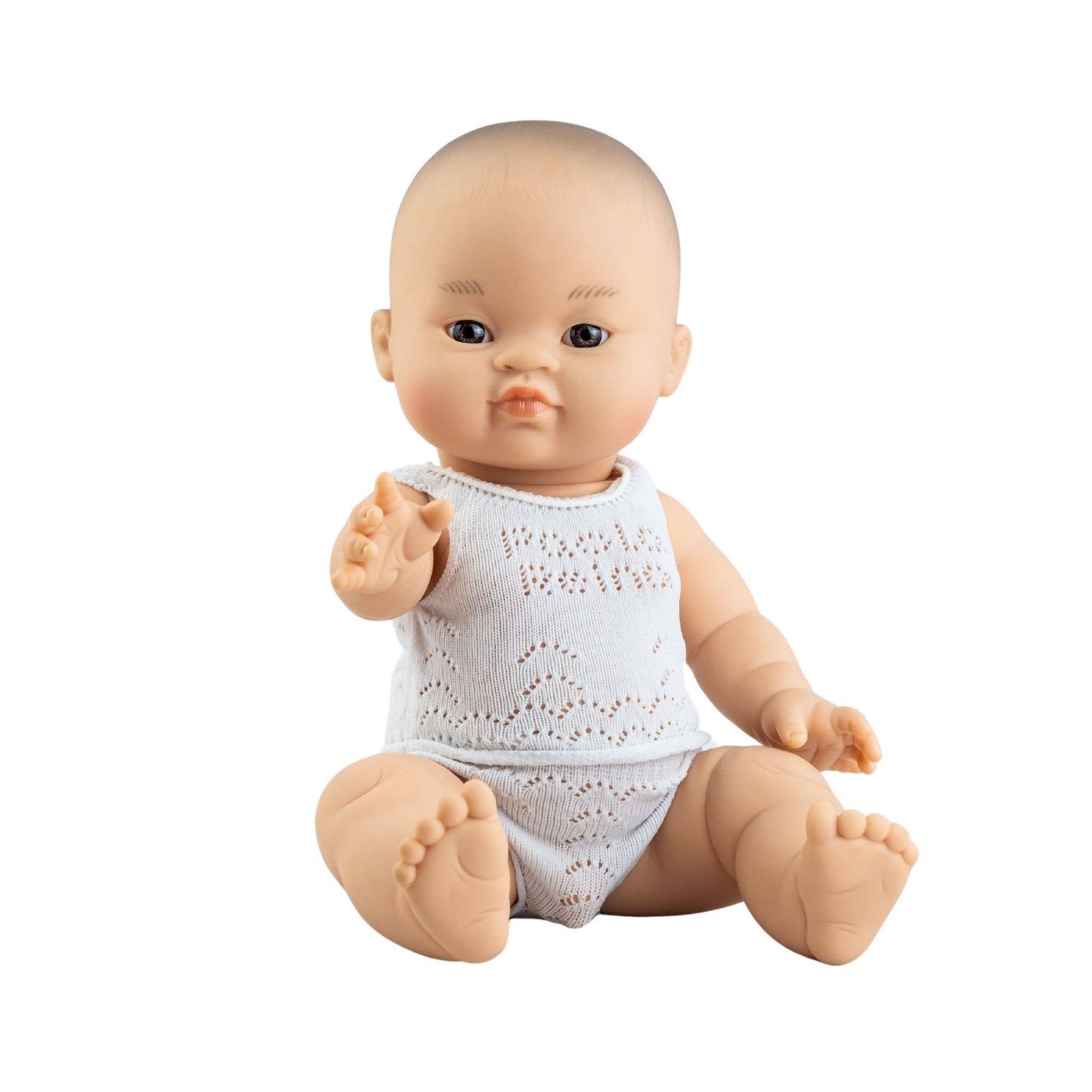 Baby doll wearing a white knitted outfit on a white background