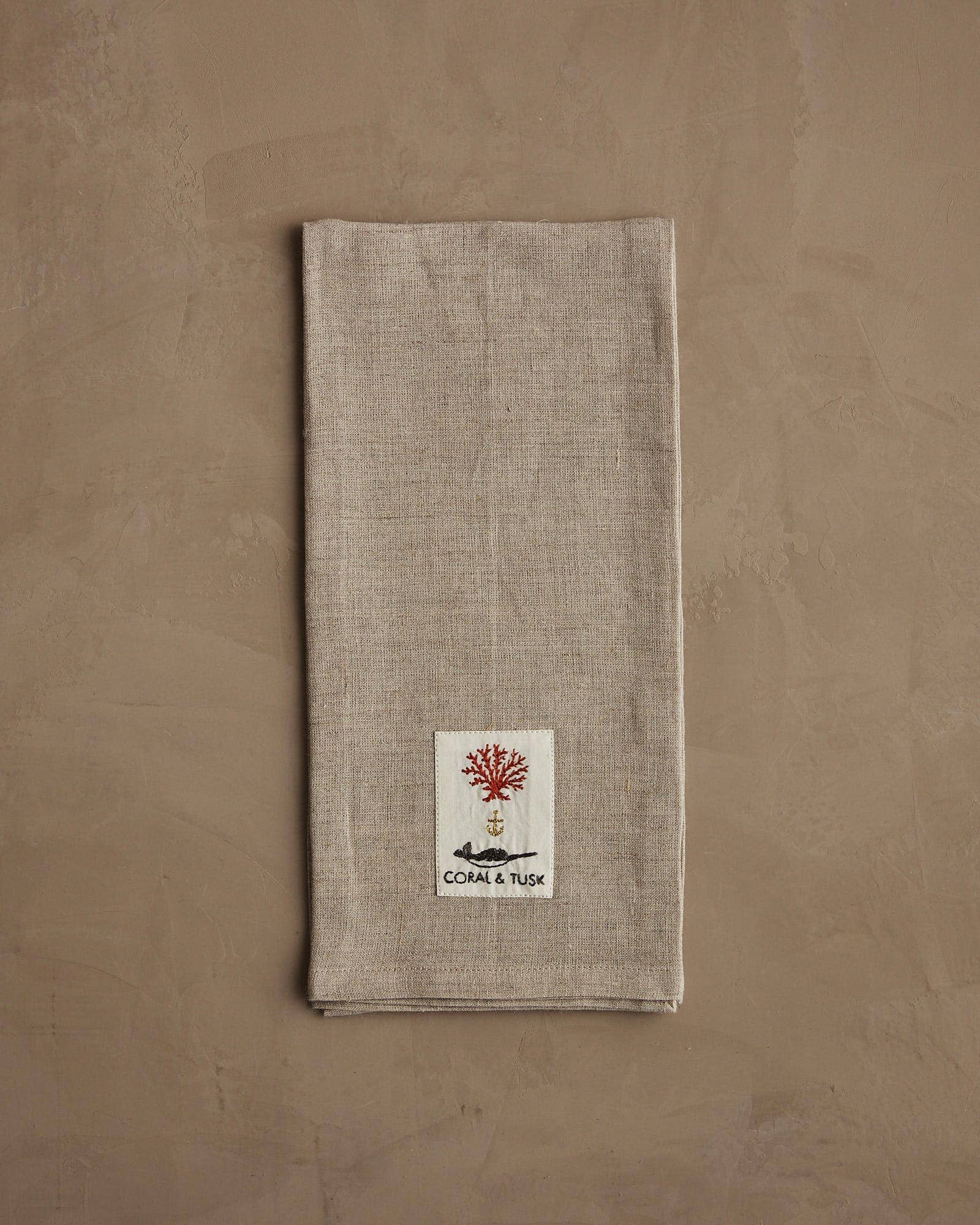 Textured napkin with a logo on a beige background