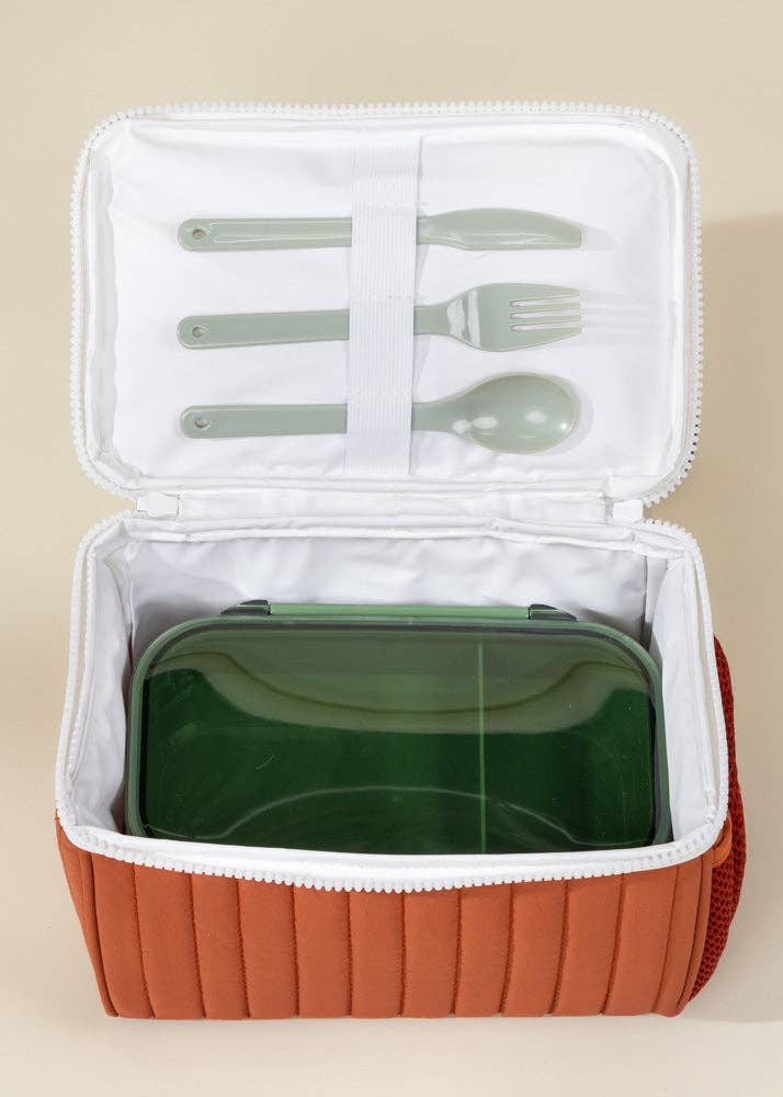 Portable lunch set with green bento box, silverware, and brown carrying case on beige background