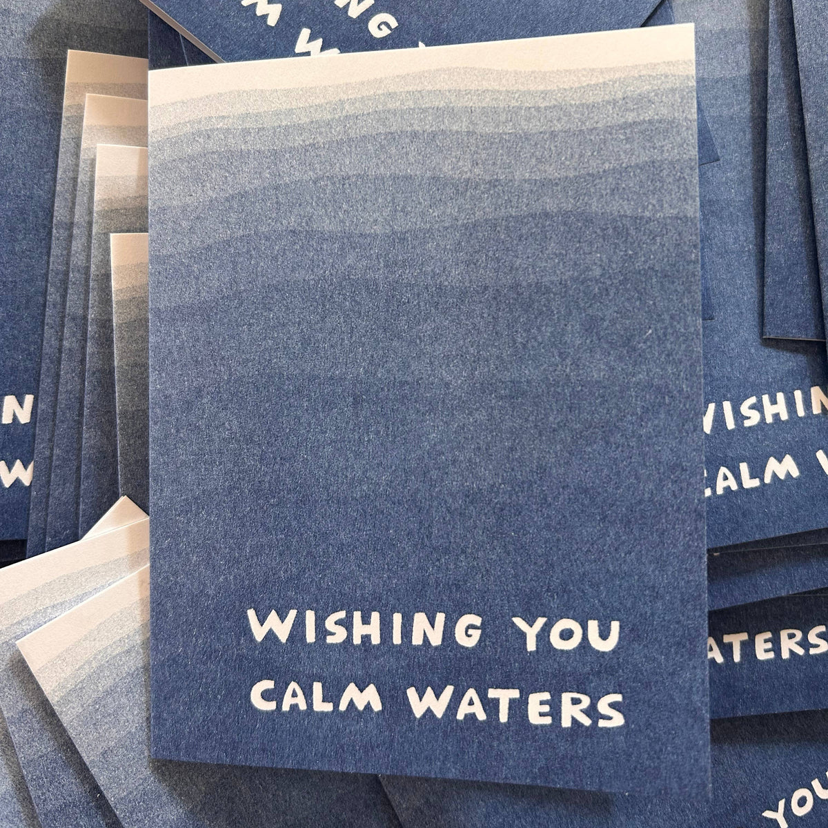 Stack of blue cards with 'Wishing You Calm Waters' text