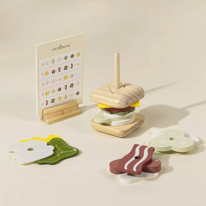 Wooden toy hamburger set with a stand on a light background