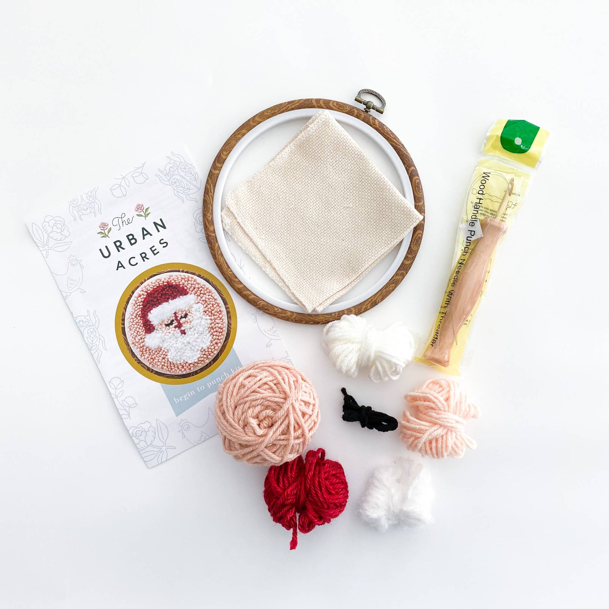 Knitting supplies including yarn, a needle, and a pattern book on a white background.
