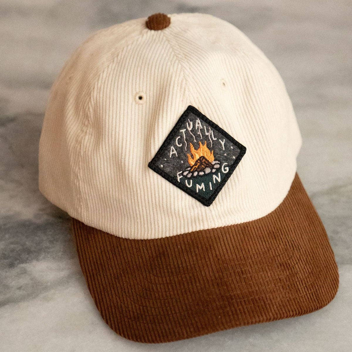 Beige and brown cap with a patch on a marble surface