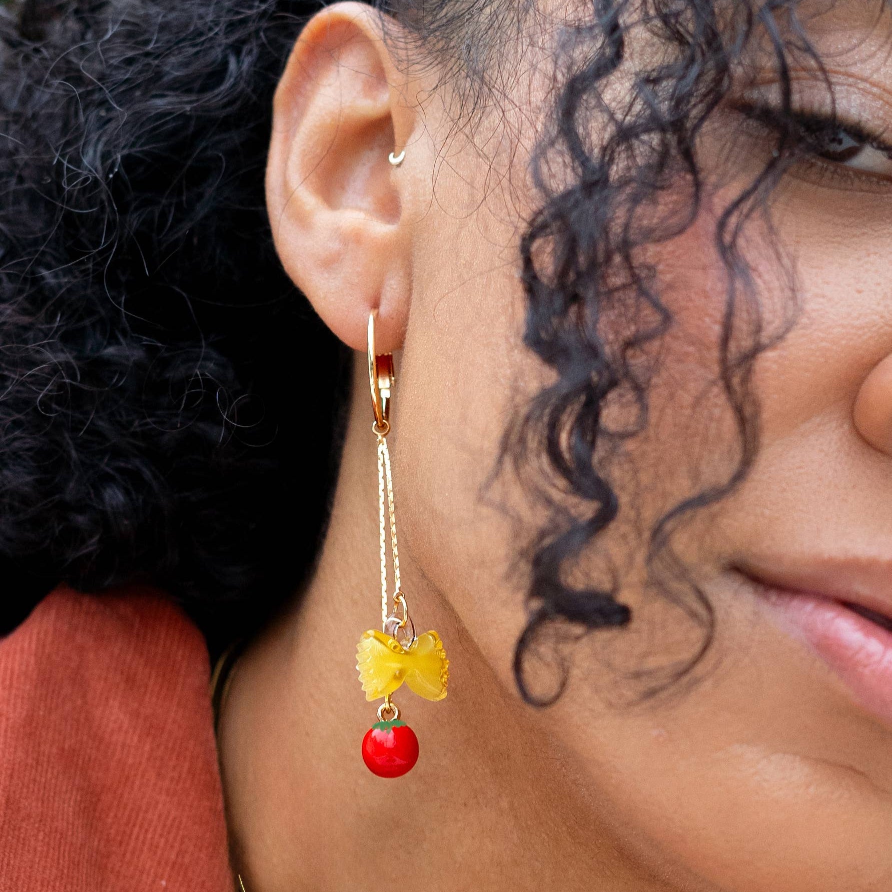 Close-up of a person wearing a colorful earring with a blurred background