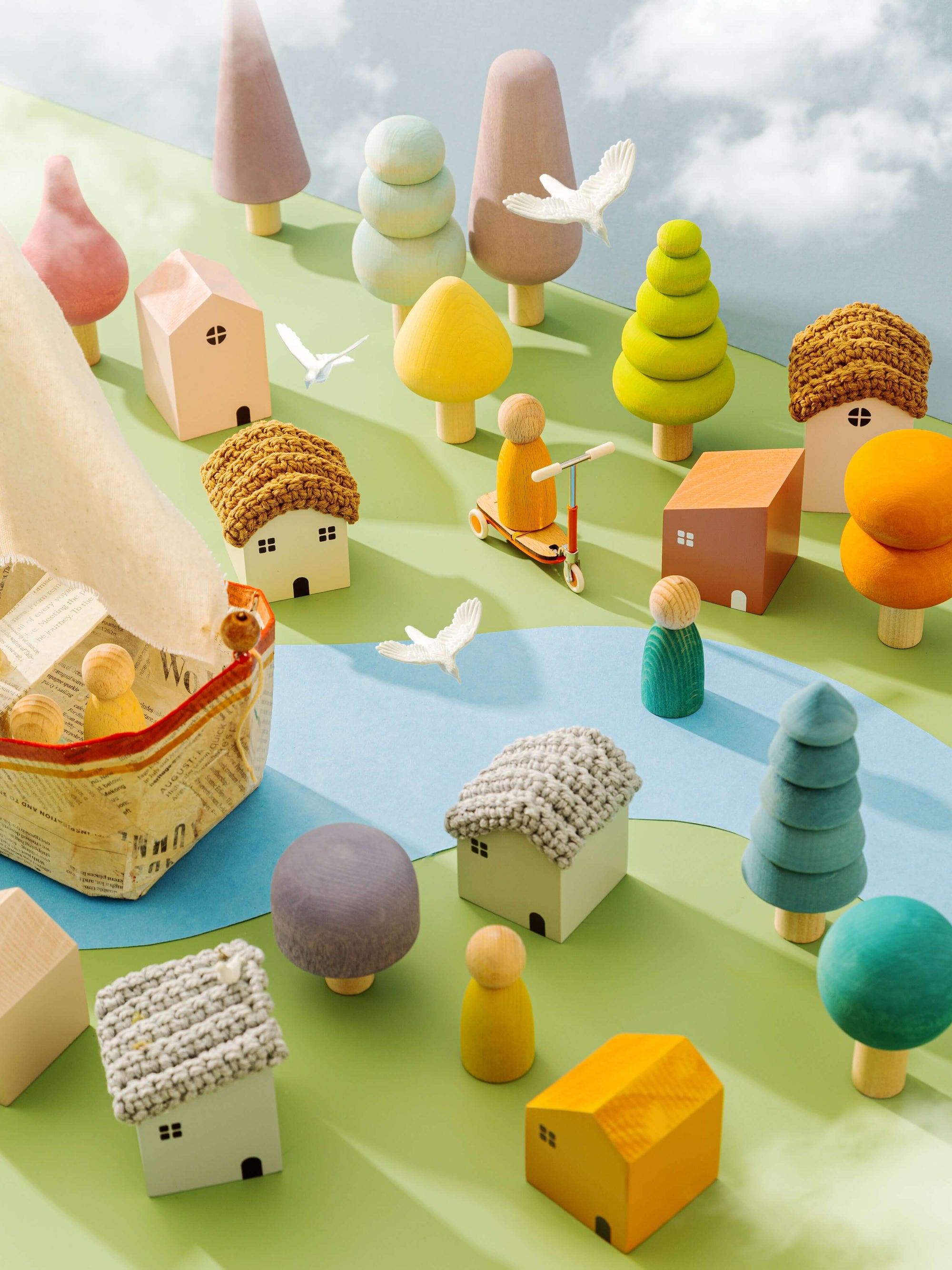 Colorful toy village with houses, trees, and people on a green surface