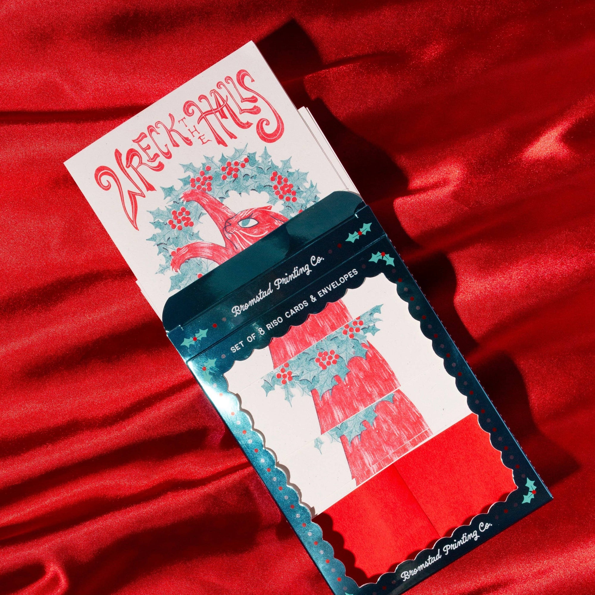 Set of cards and envelopes with decorative design on a red fabric background