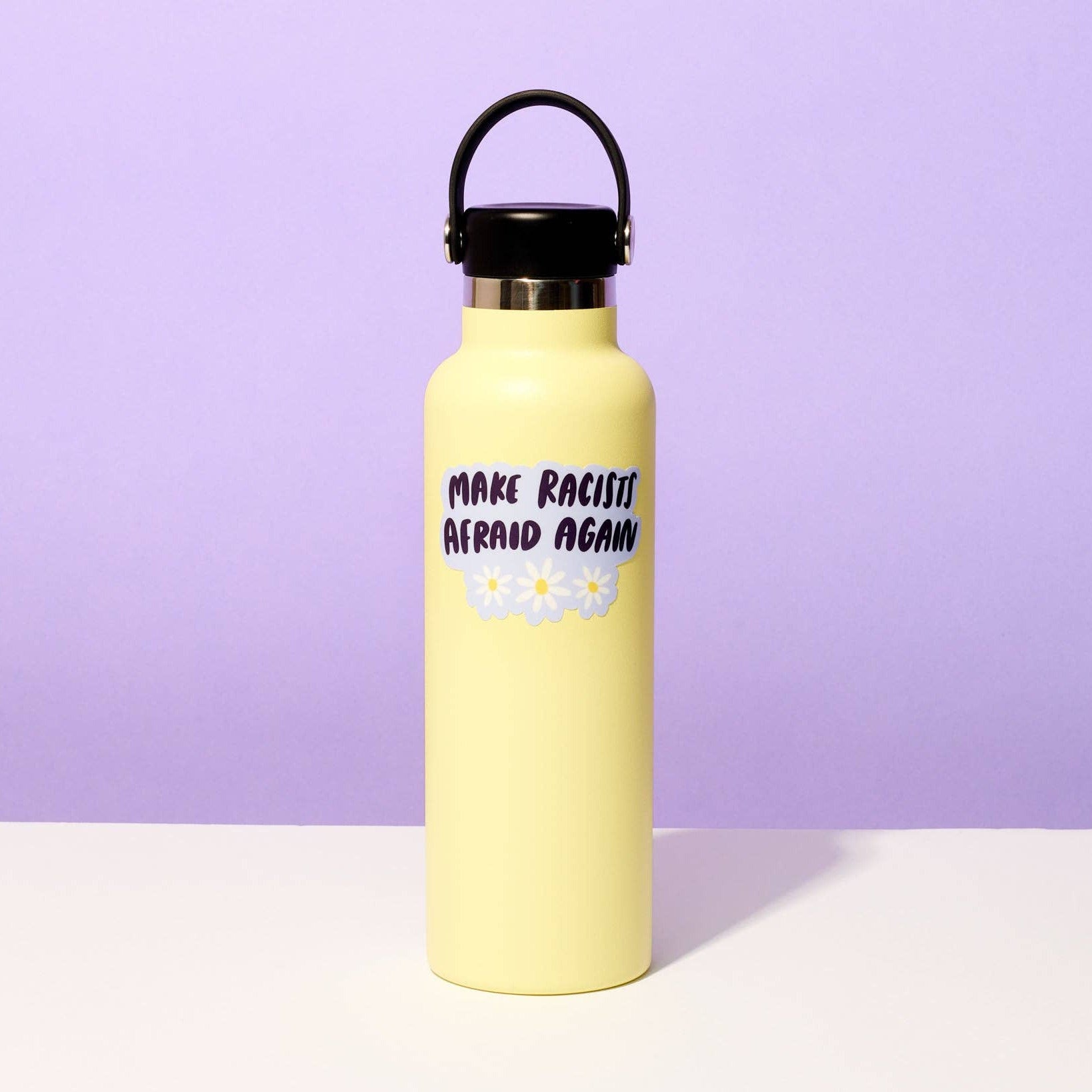 Yellow water bottle with text and a flower graphic on a purple background