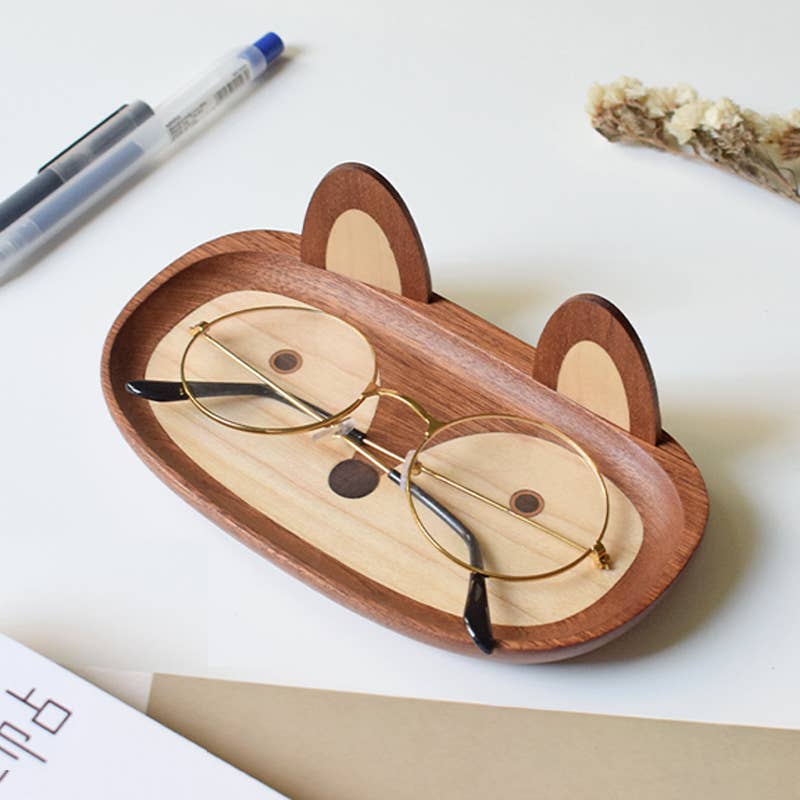Wooden eyeglass case shaped like a fox with glasses inside on a white surface.