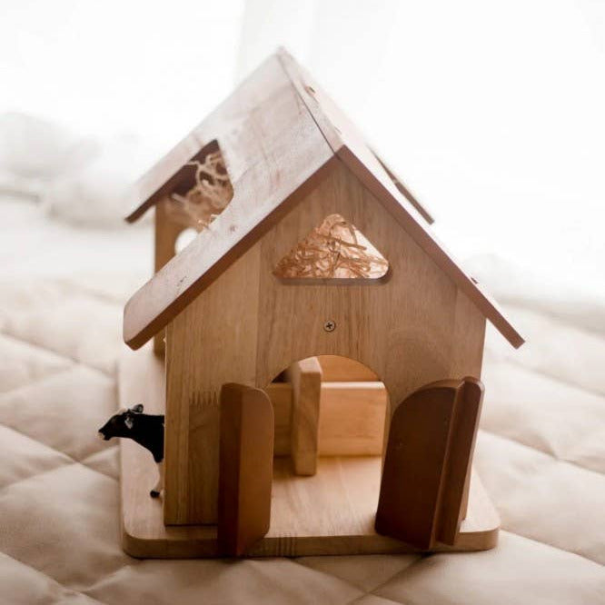 Wooden house with a small cow peeking out on a textured surface