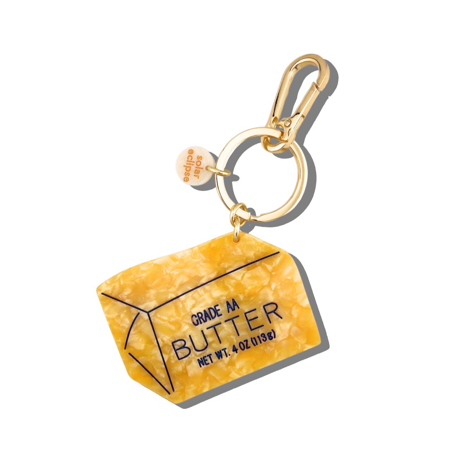 Butter container keychain with gold clasp on a white background