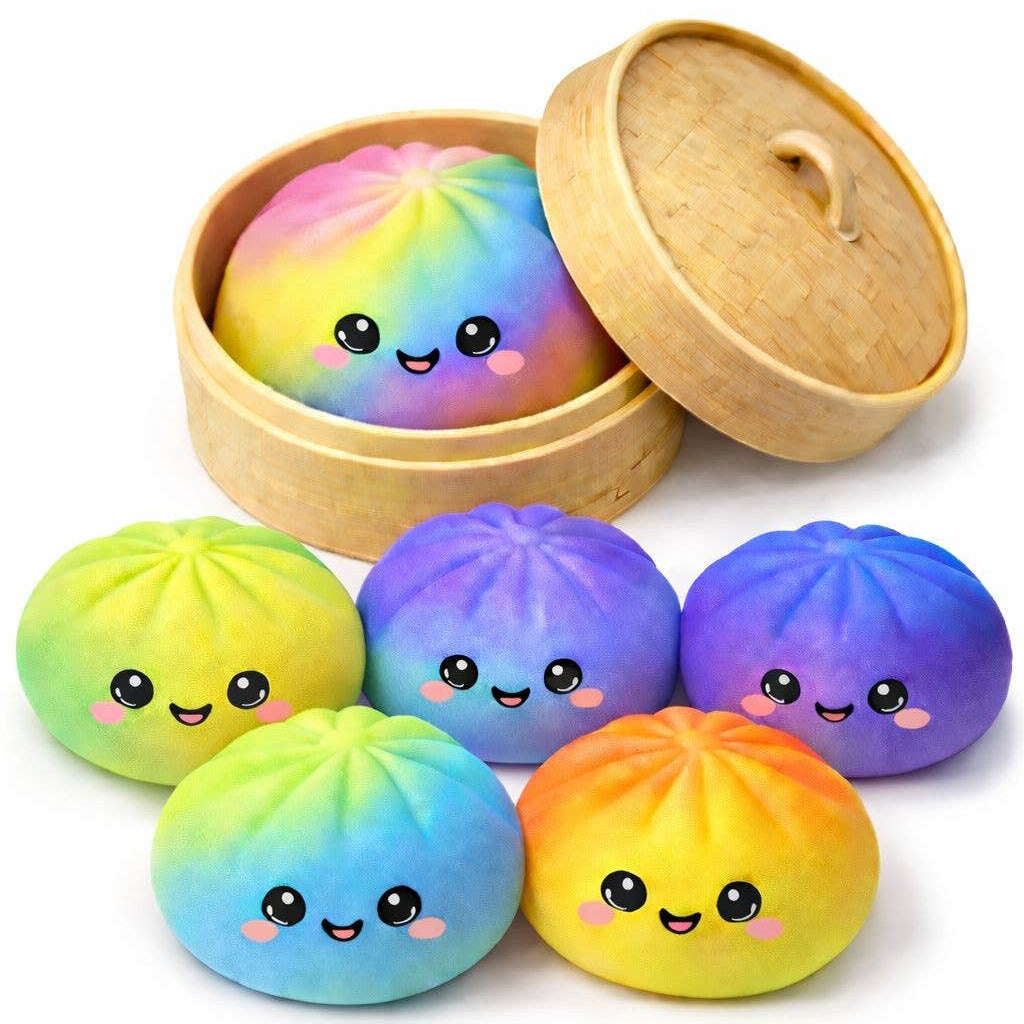 Colorful dumpling-shaped bath bombs with smiling faces in a wooden steamer basket on a white background.