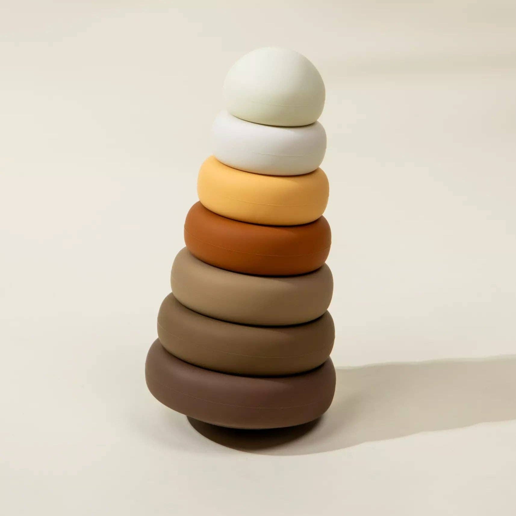 Stack of colorful wooden rings on a beige background
