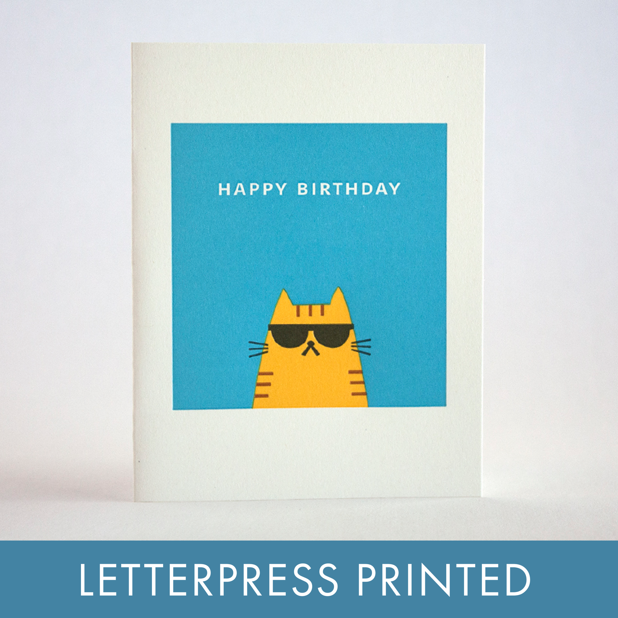 Birthday card with a cat wearing sunglasses on a blue background, letterpress printed text.