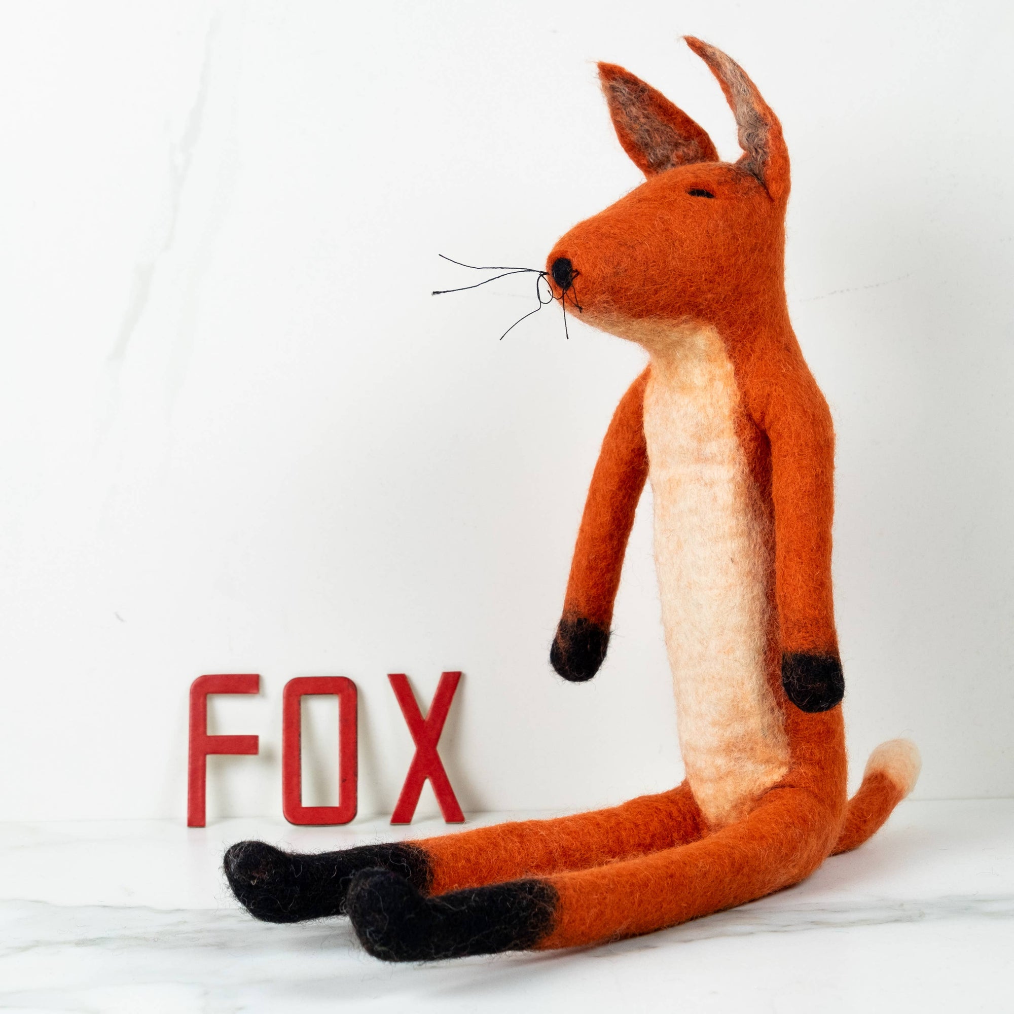 Stuffed fox toy with 'FOX' letters on a white background