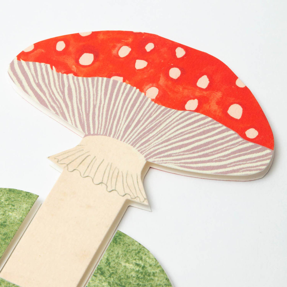 Mushroom-shaped object with red cap and white spots on a light gray background