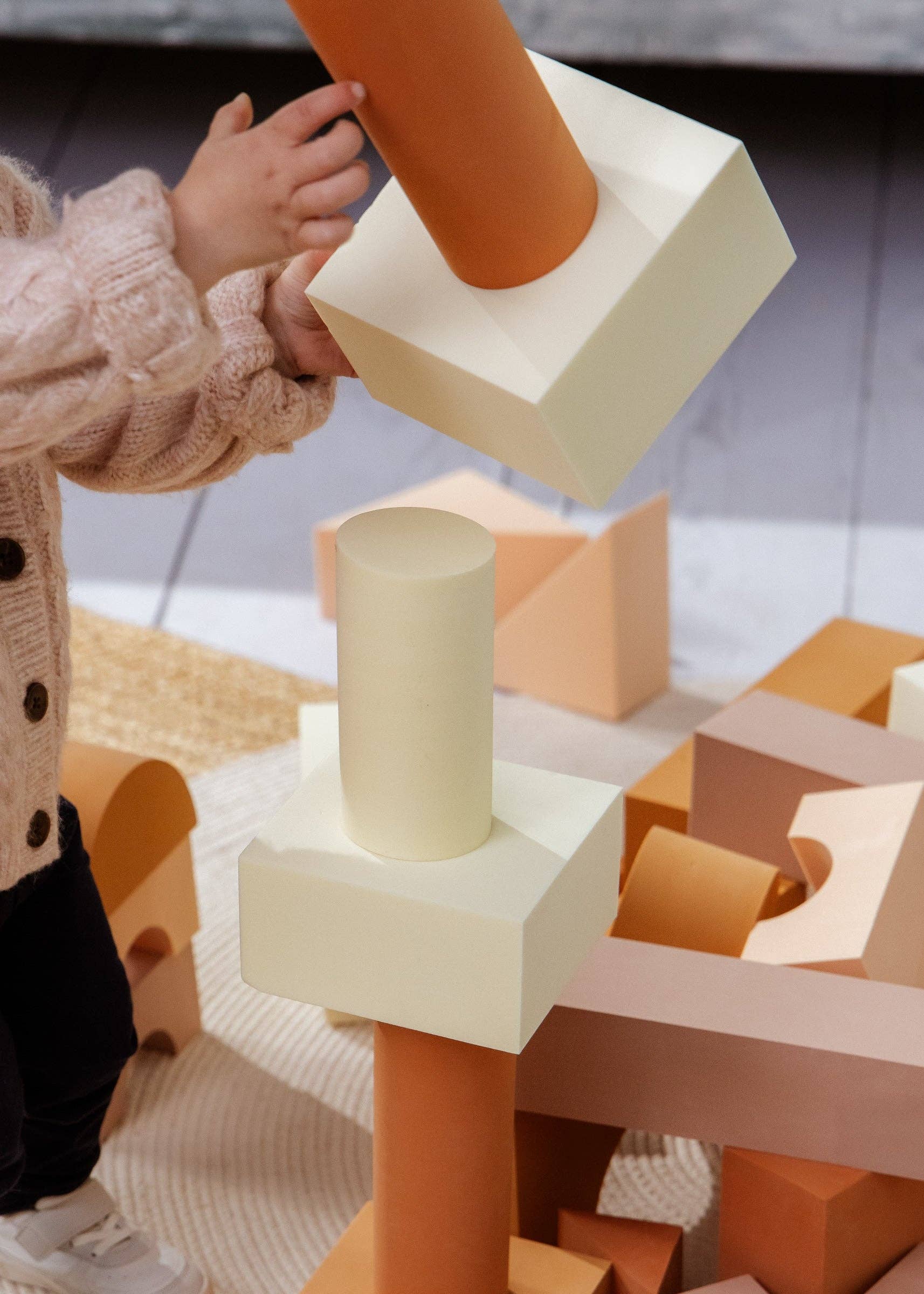 Child playing with geometric foam blocks in a playful setting
