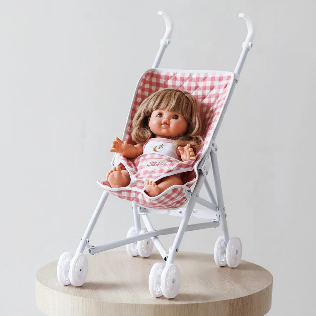 Doll in a pink checkered stroller on a light gray background