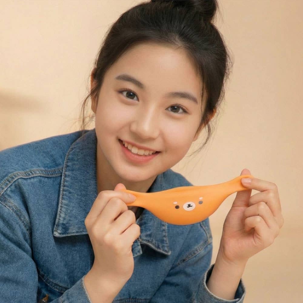 Person holding an orange object with a bear design against a beige background